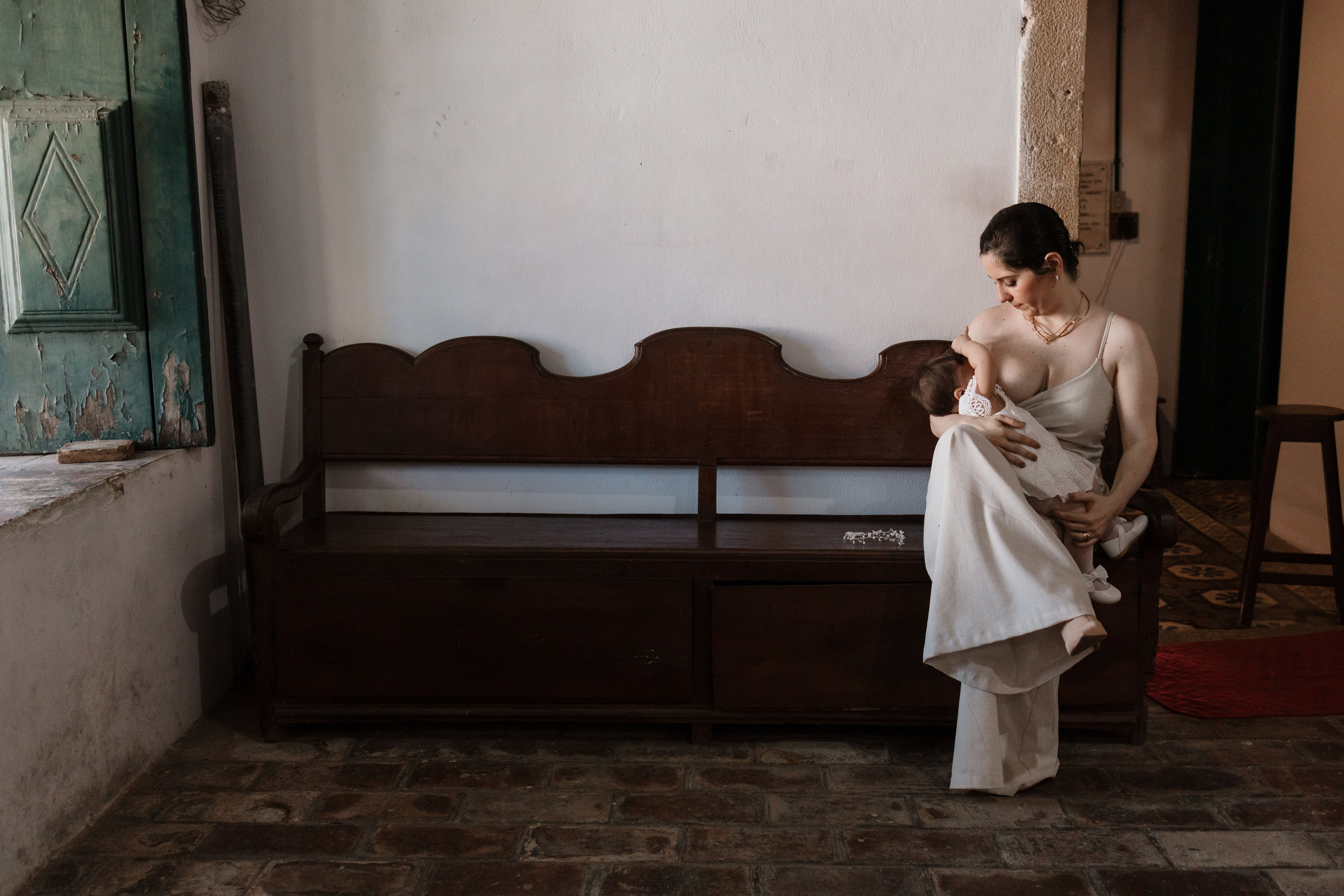 Mãe amamentando filha antes do batismo