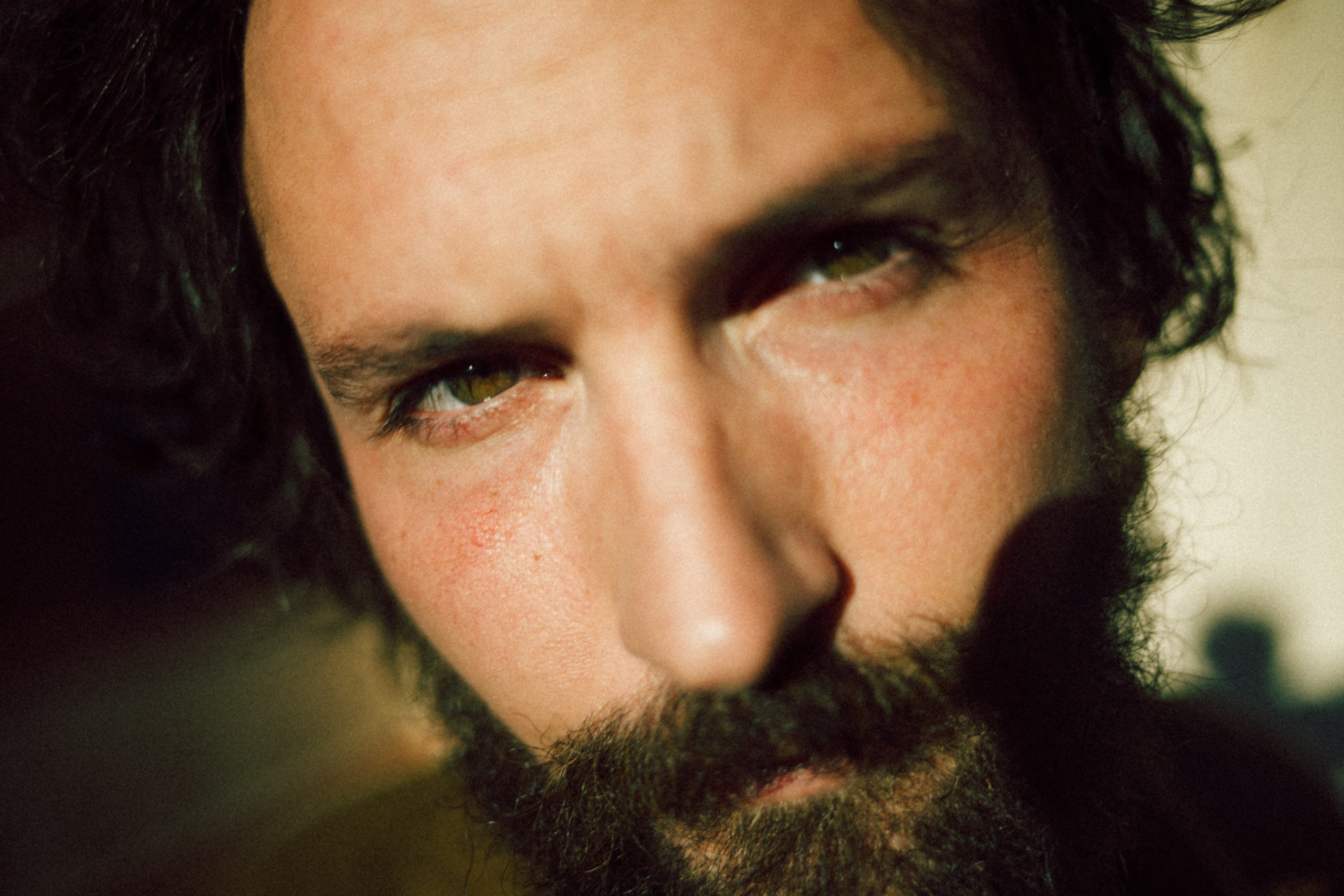 Portrait of a man with intense gaze and a beard, shot close-up