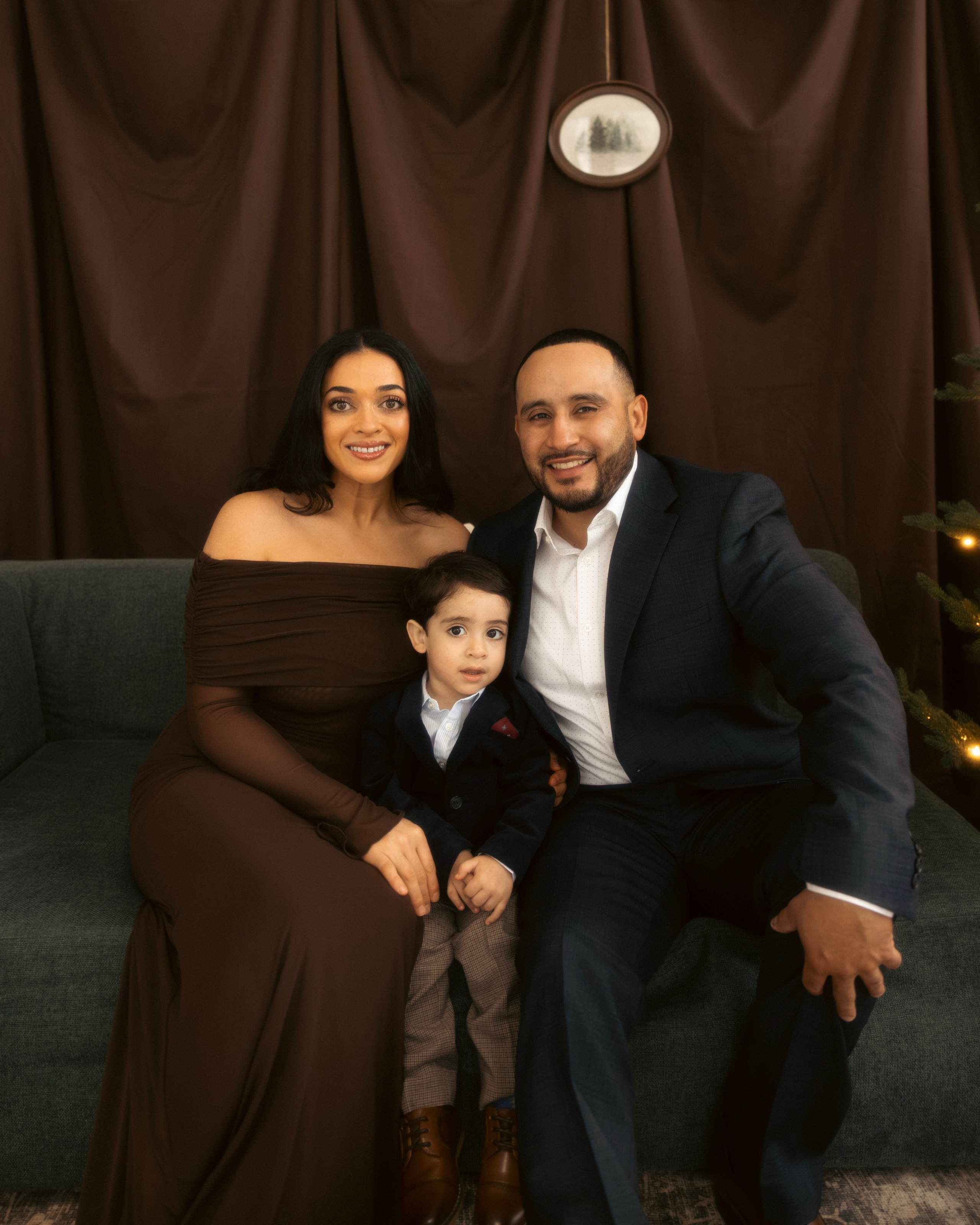 Couple hugging near Christmas tree in warm Christmas photoshoot