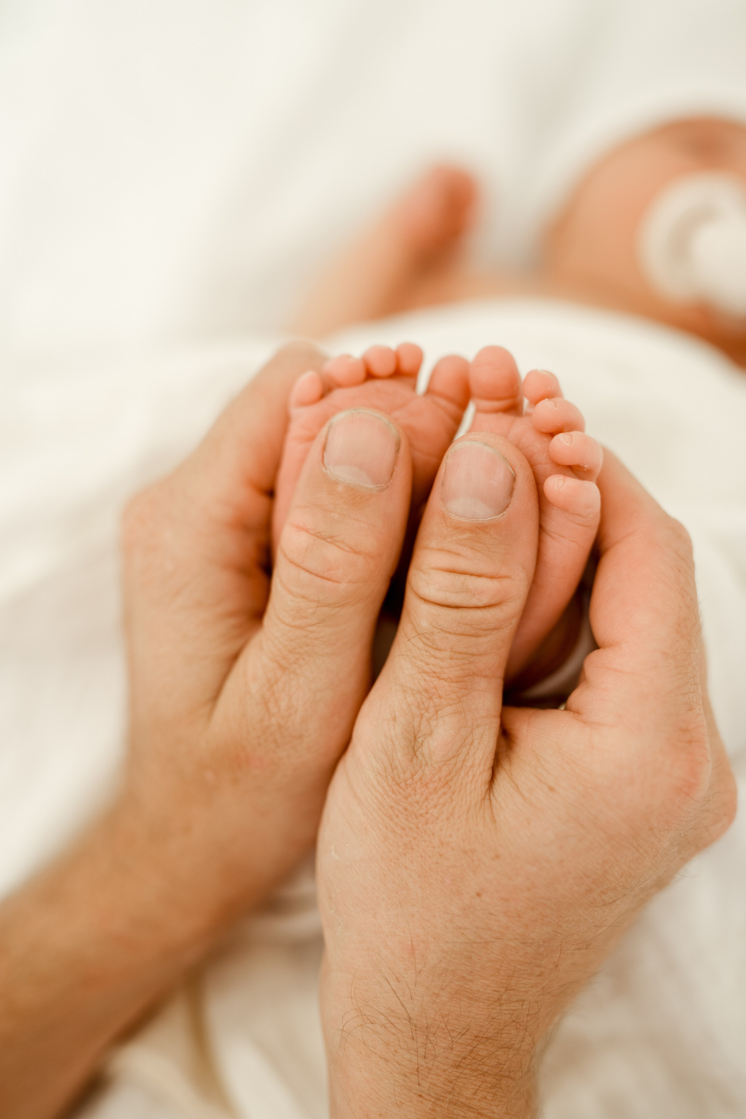 Tata trzymający stopy noworodka – fotograf w Łodzi