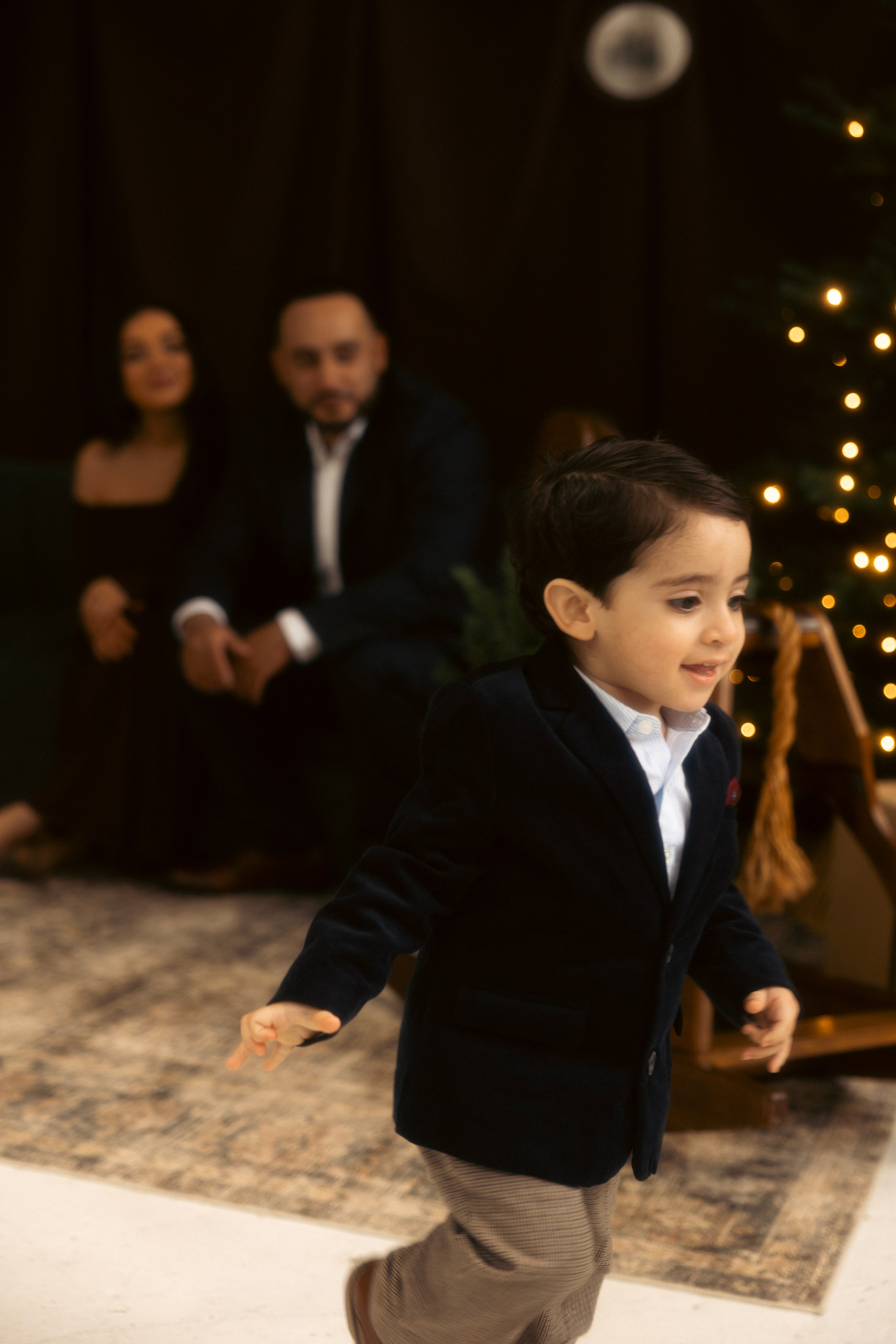 Couple Christmas portraits in studio with festive décor and warm tones