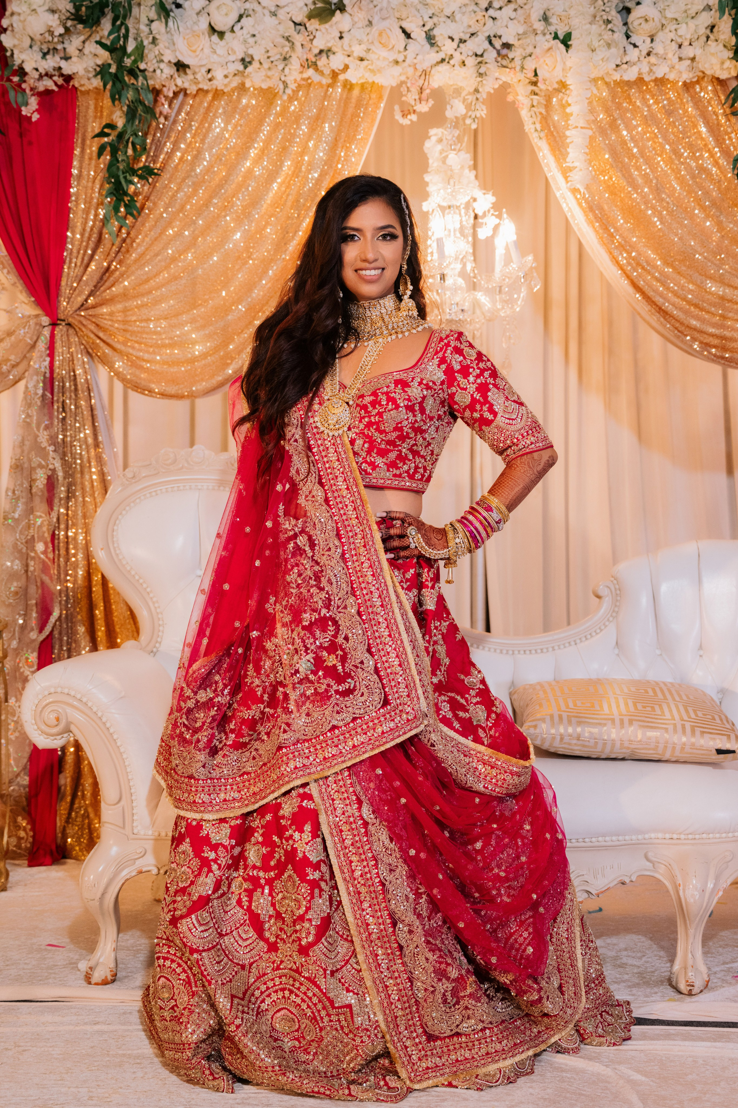 a bride in a red lehen with gold and red embroidery