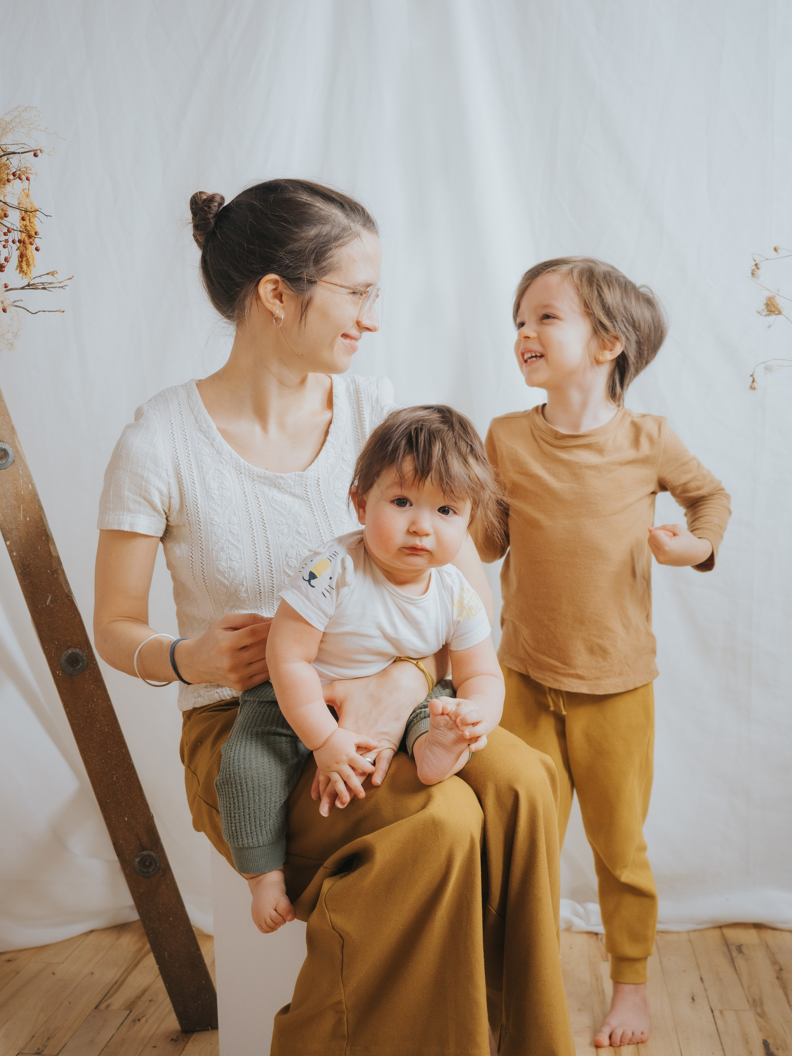 Mother and two young boys dancing together.