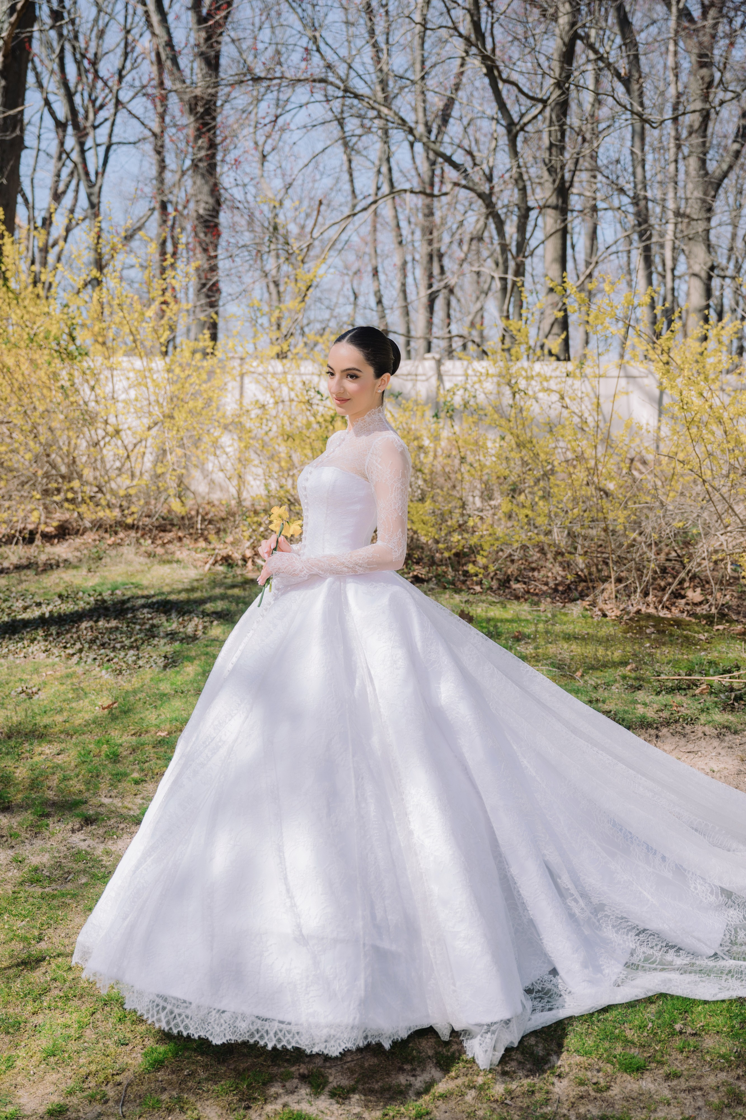 a bride in a white wedding dress standing in the grass