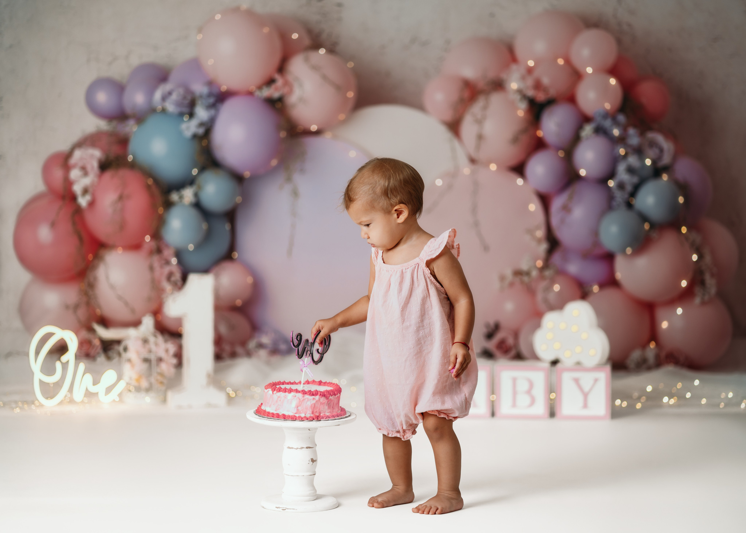 Fotografisanje prvog rođendana u studiju sa pastelnom tortom i balonima