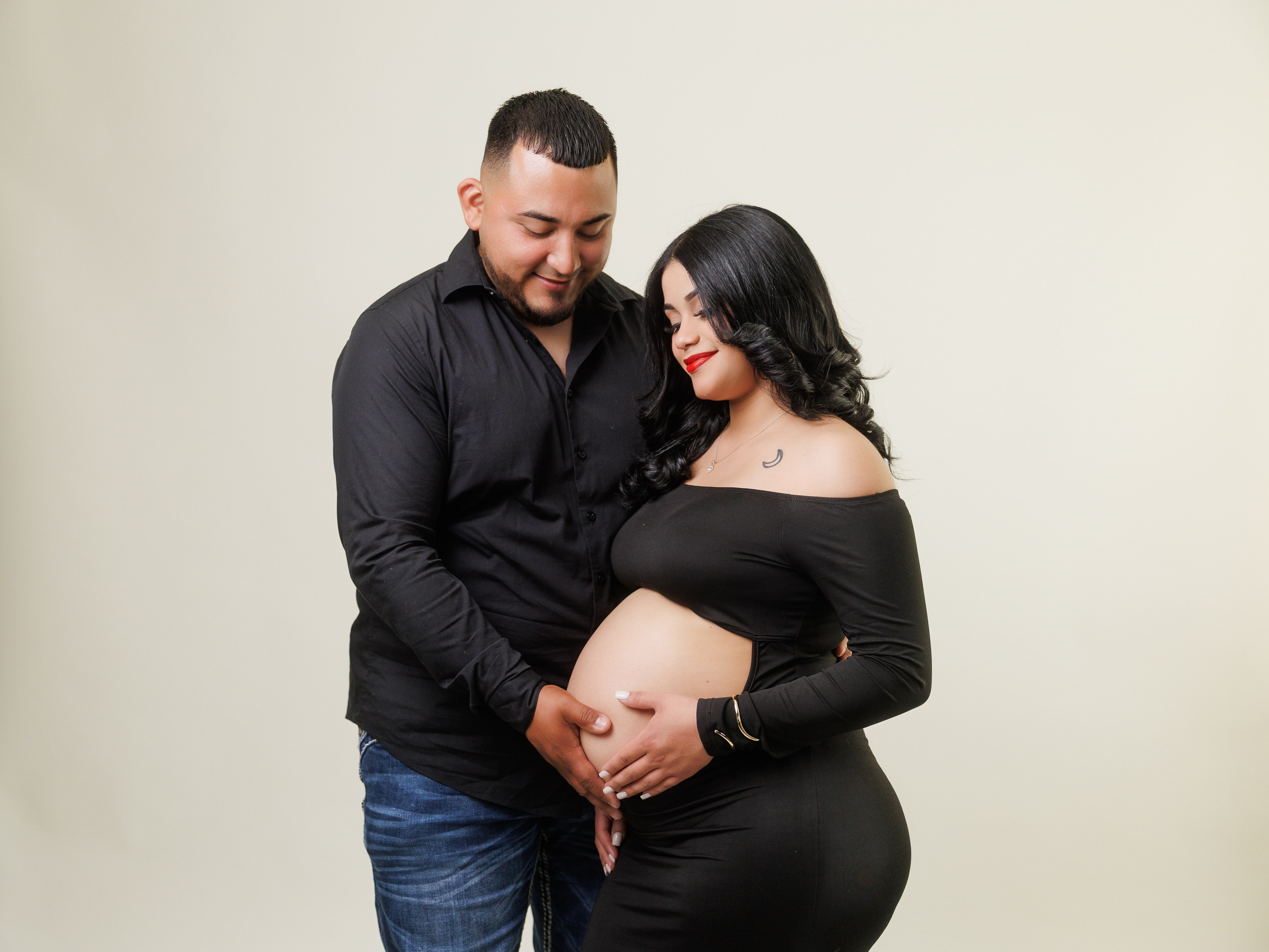 Intimate studio maternity portrait session with expectant parents in elegant black attire Indianapolis