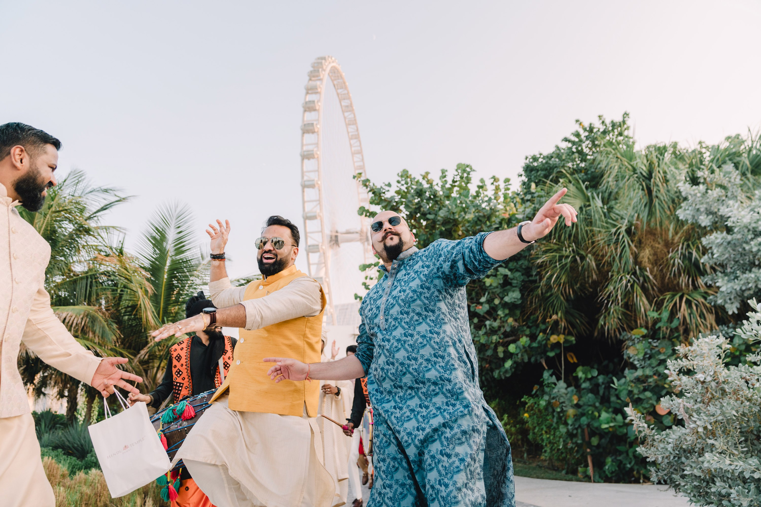 Two guests dressed in blue and yellow sari are dancing