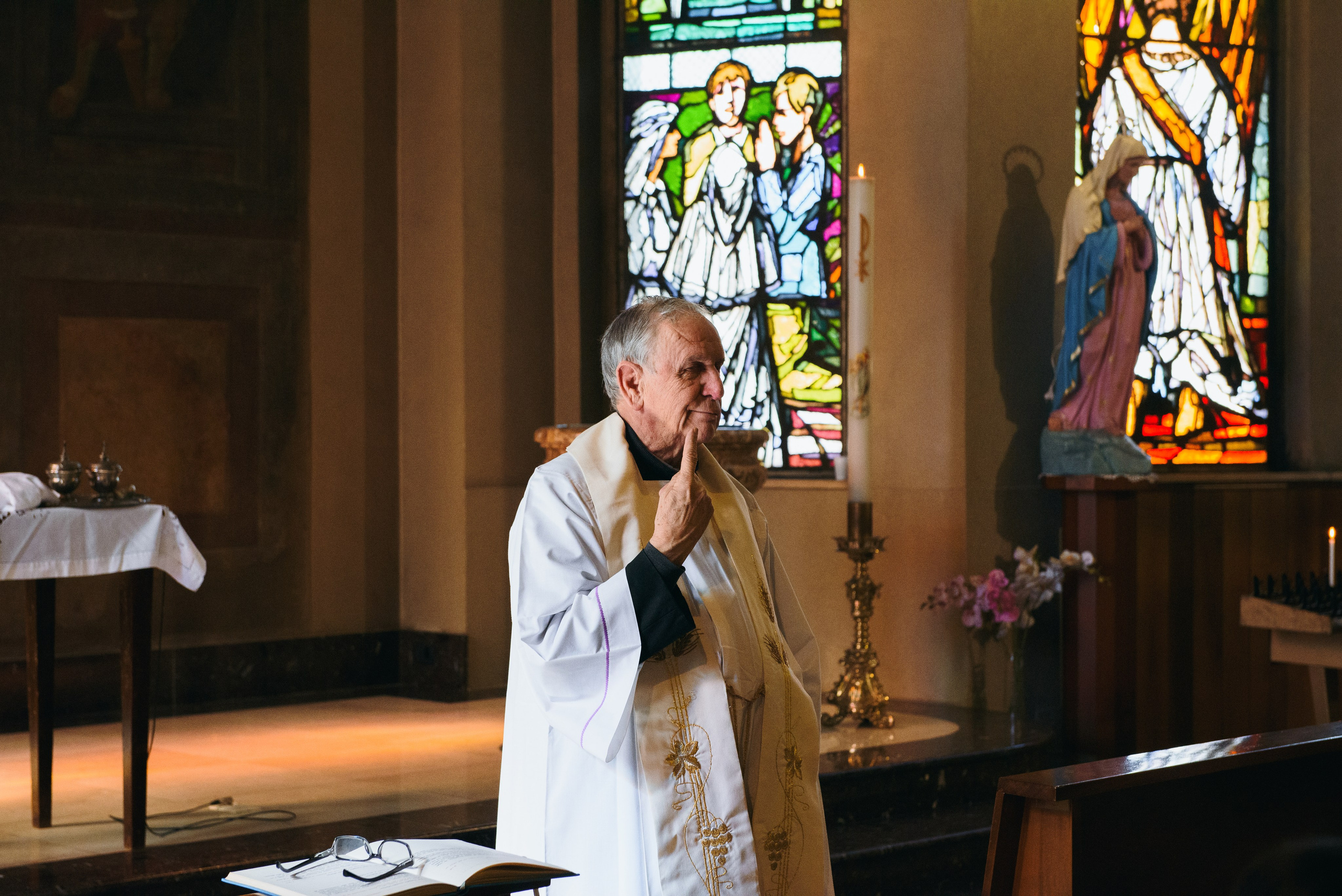 Photographer priest in church in Milan. Baptism Photographer
