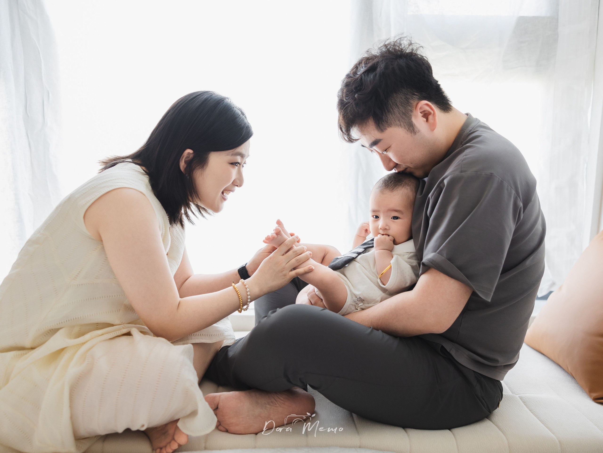 A 100-day-old baby with his parents during a natural family photography session at home in Shanghai.