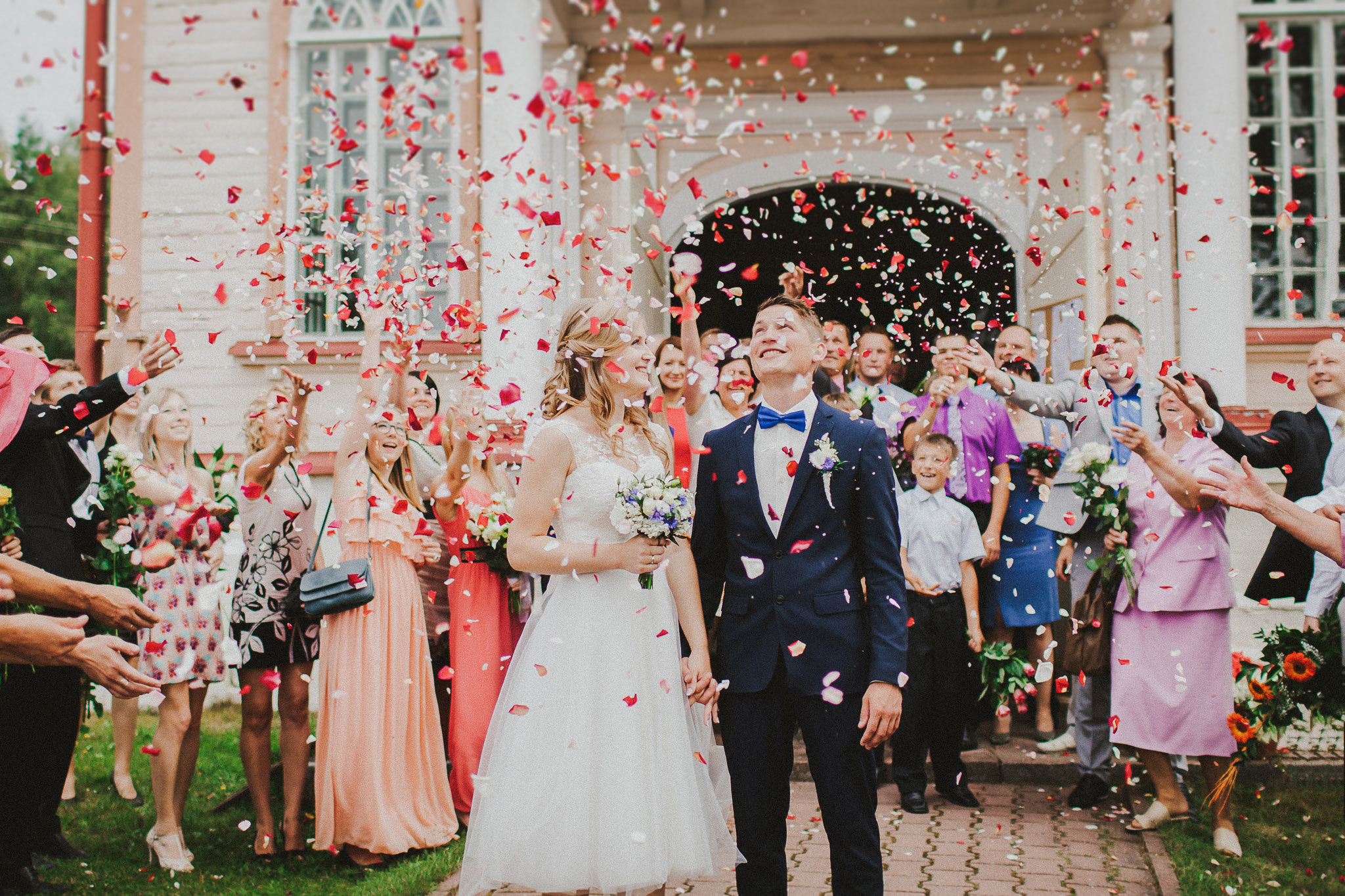 Kāzu foto mirklis, kad jauno pāri sveic ar ziediem