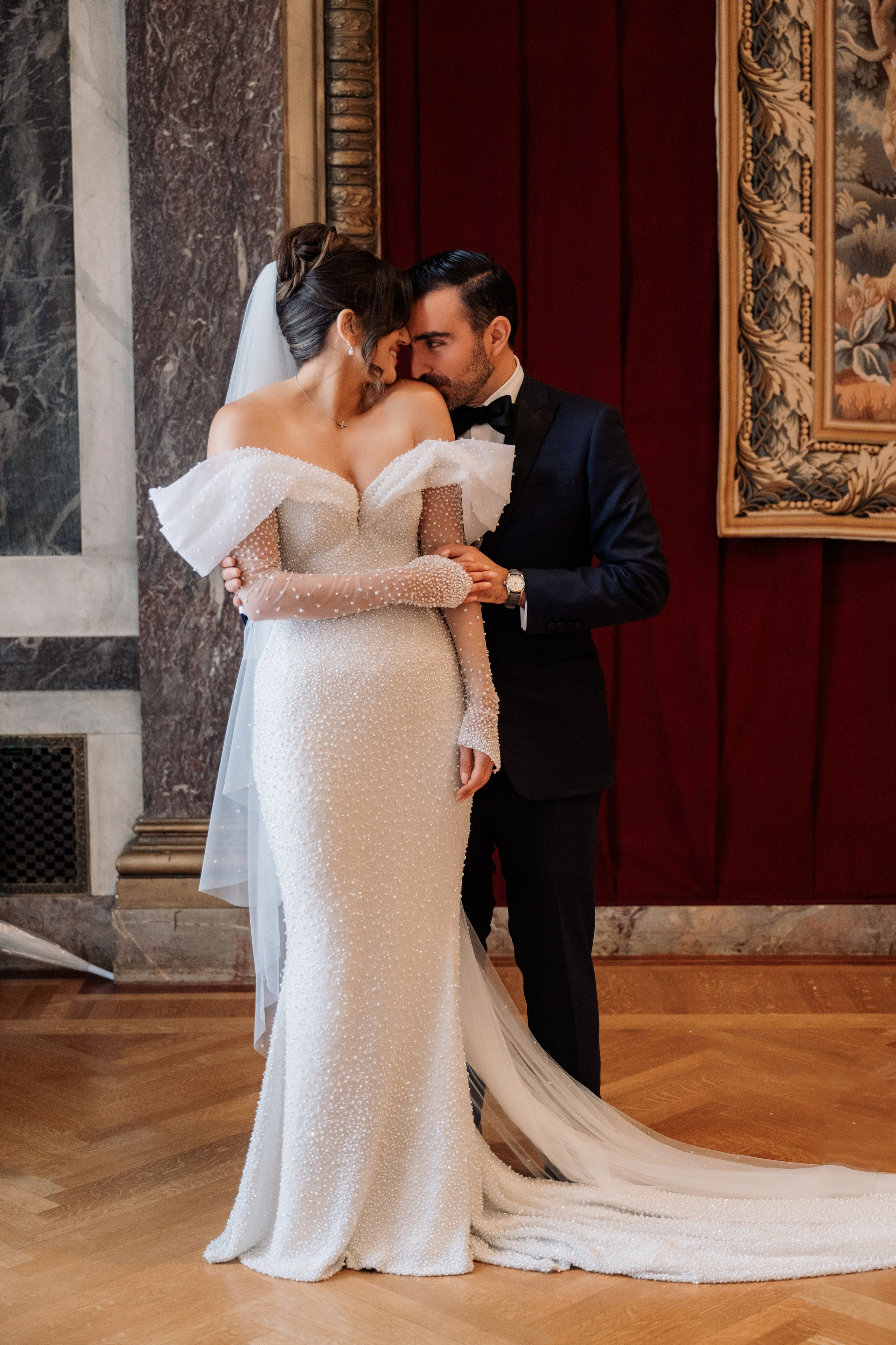 a bride and groom kissing in front of a painting