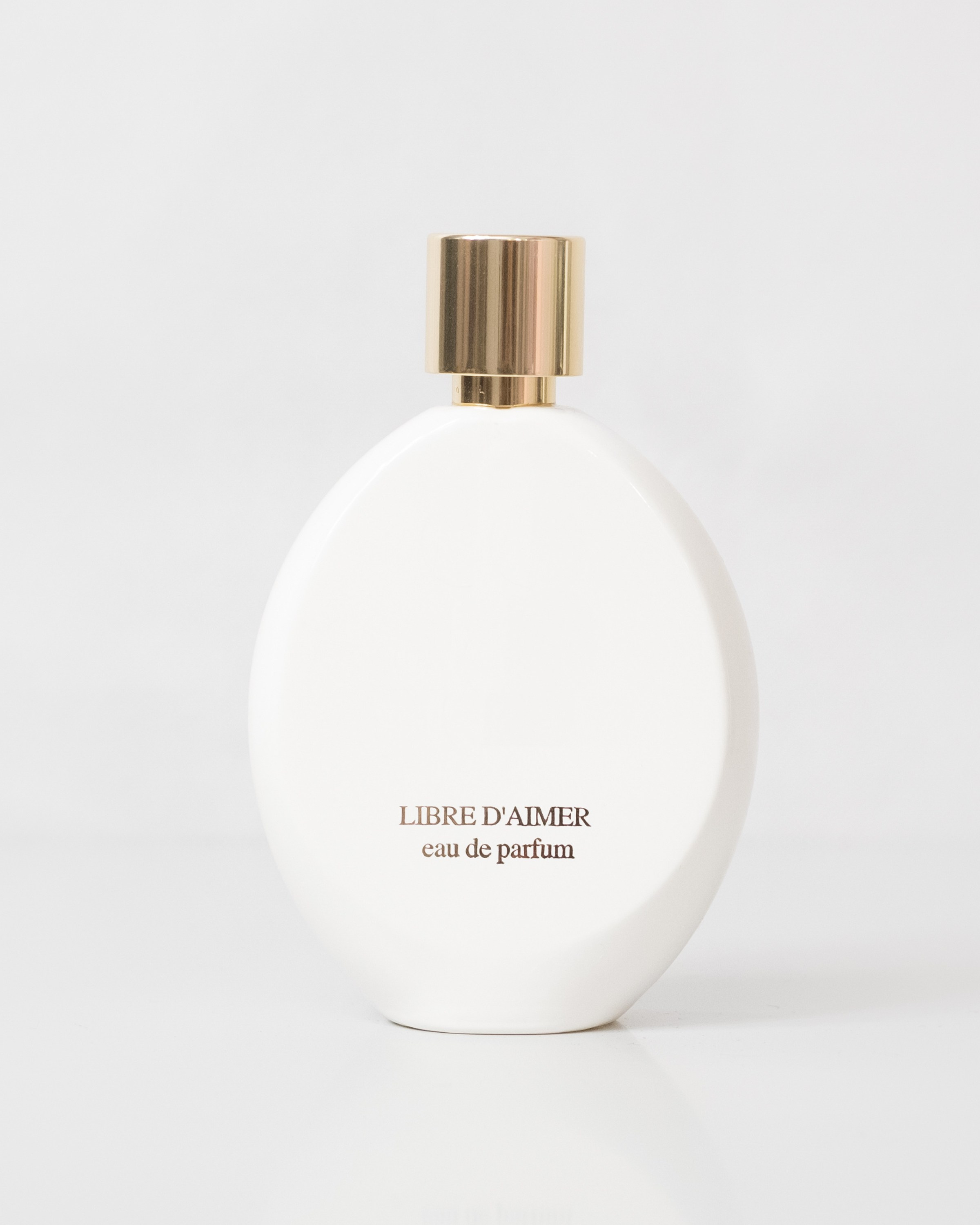 Elegant white perfume bottle with a minimalistic design.