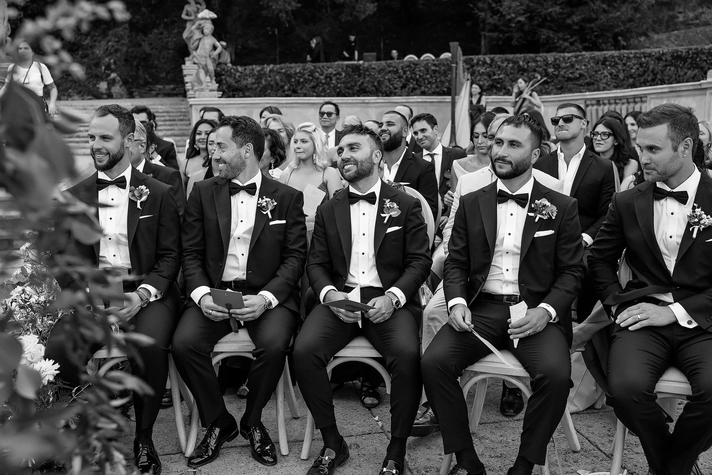 A classic black and white image of a wedding party, featuring guests in formal wear and a festive atmosphere.