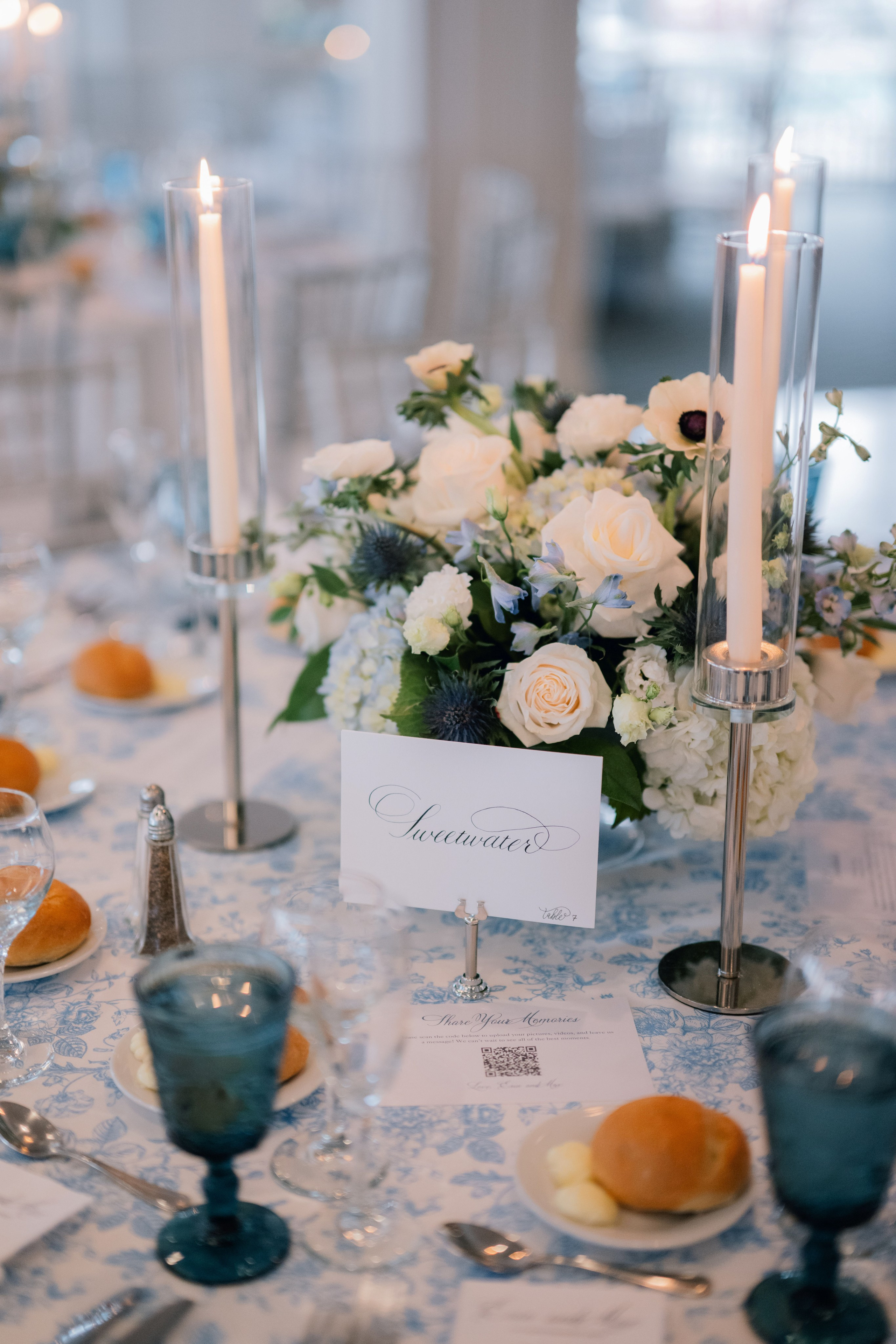 a table with a white table cloth and a blue and white centerpiece