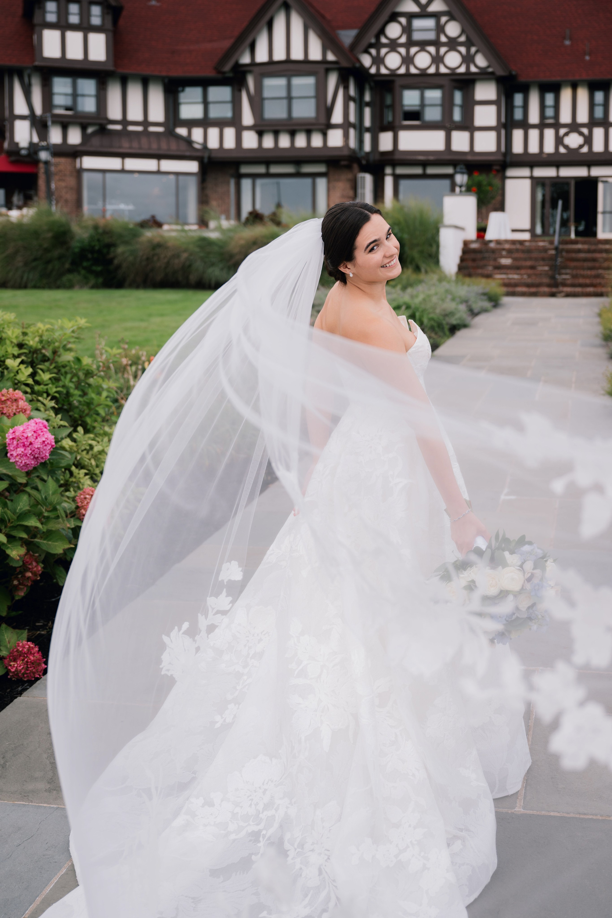 a bride in a wedding dress and veil walking down the street