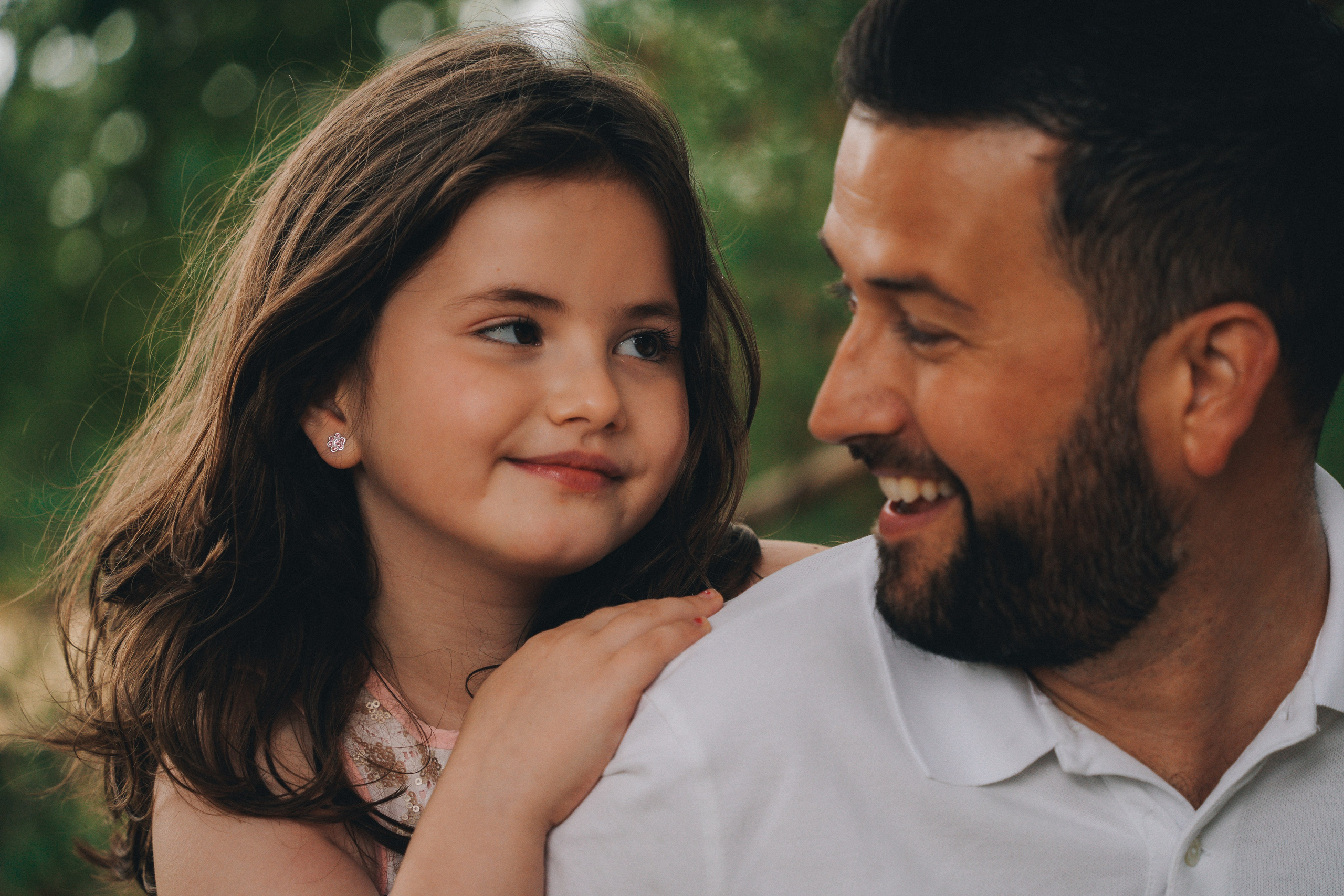 Family portrait of parents and daughter sharing a calm moment outdoors, Solihull family photography