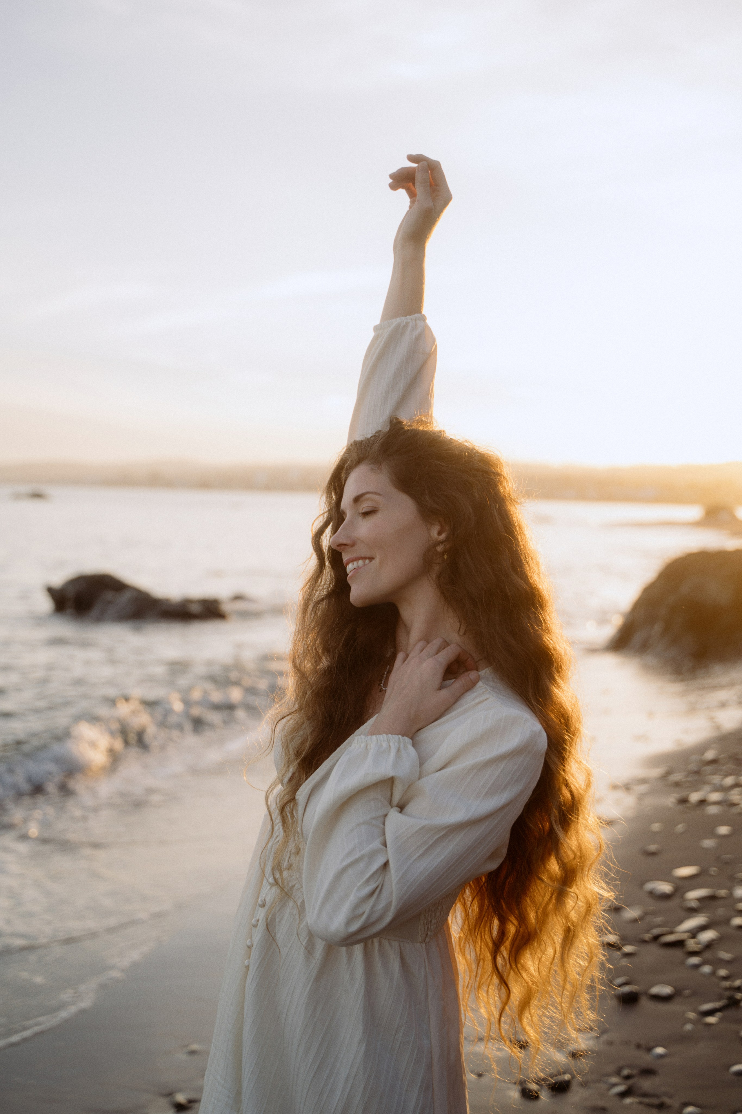 Portrait of a long red-haired woman on the beach