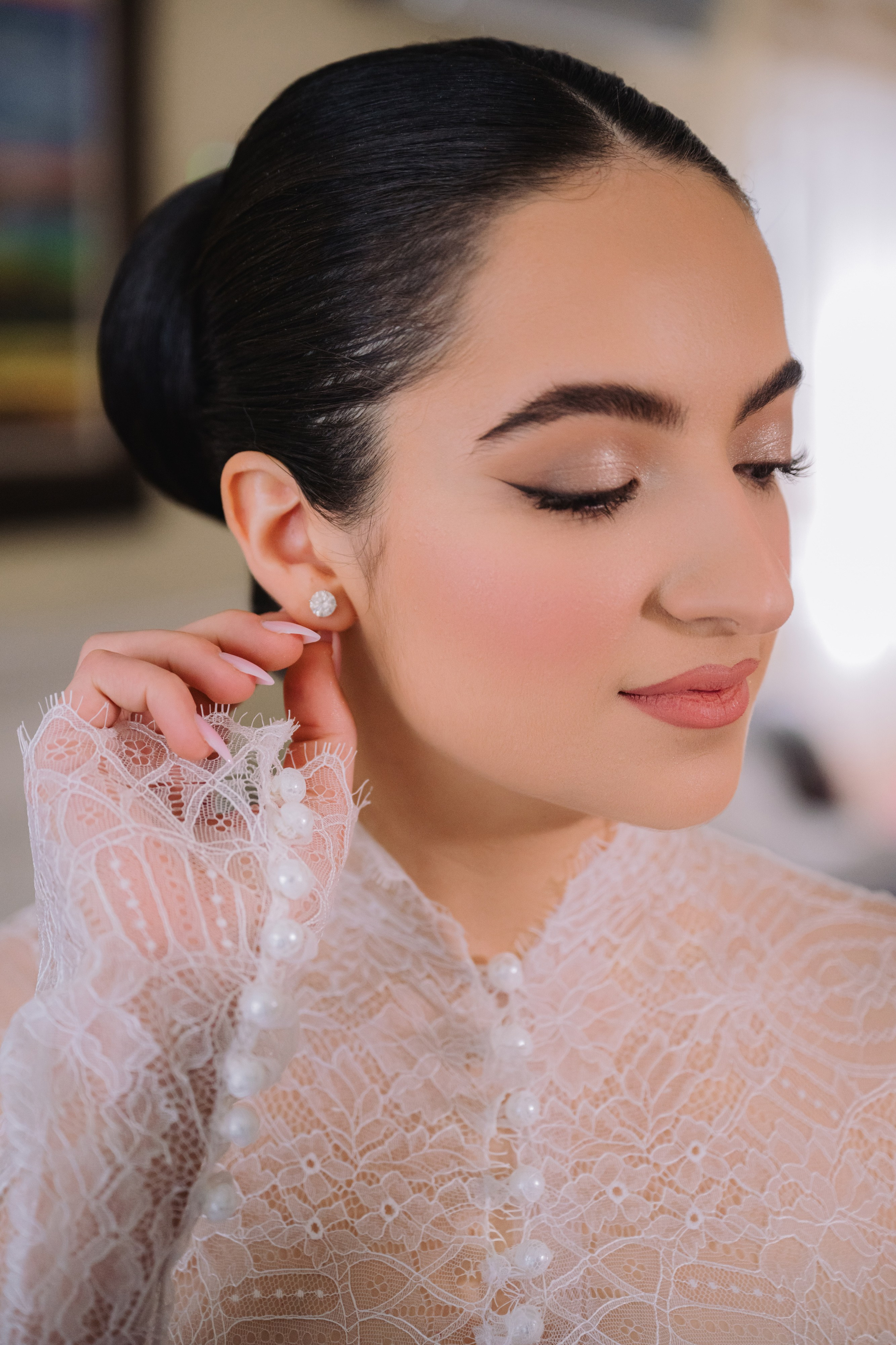 a woman with a white dress and pearl earrings