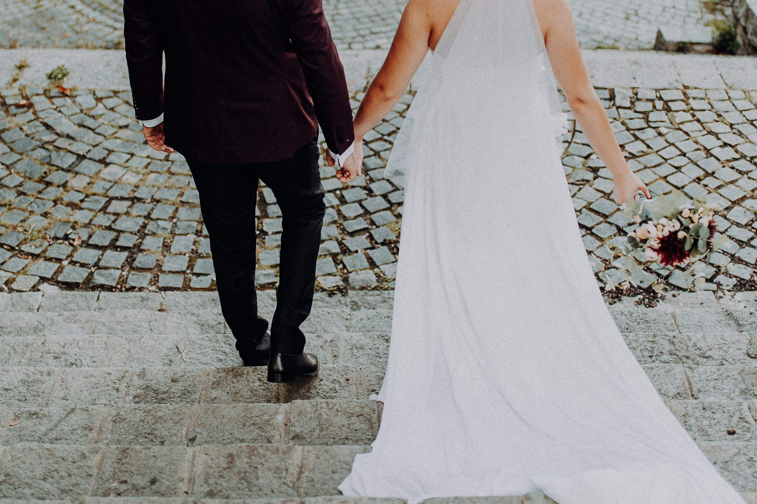 Mirii coborând treptele ținându-se de mână, surprinși într-un cadru natural și elegant.