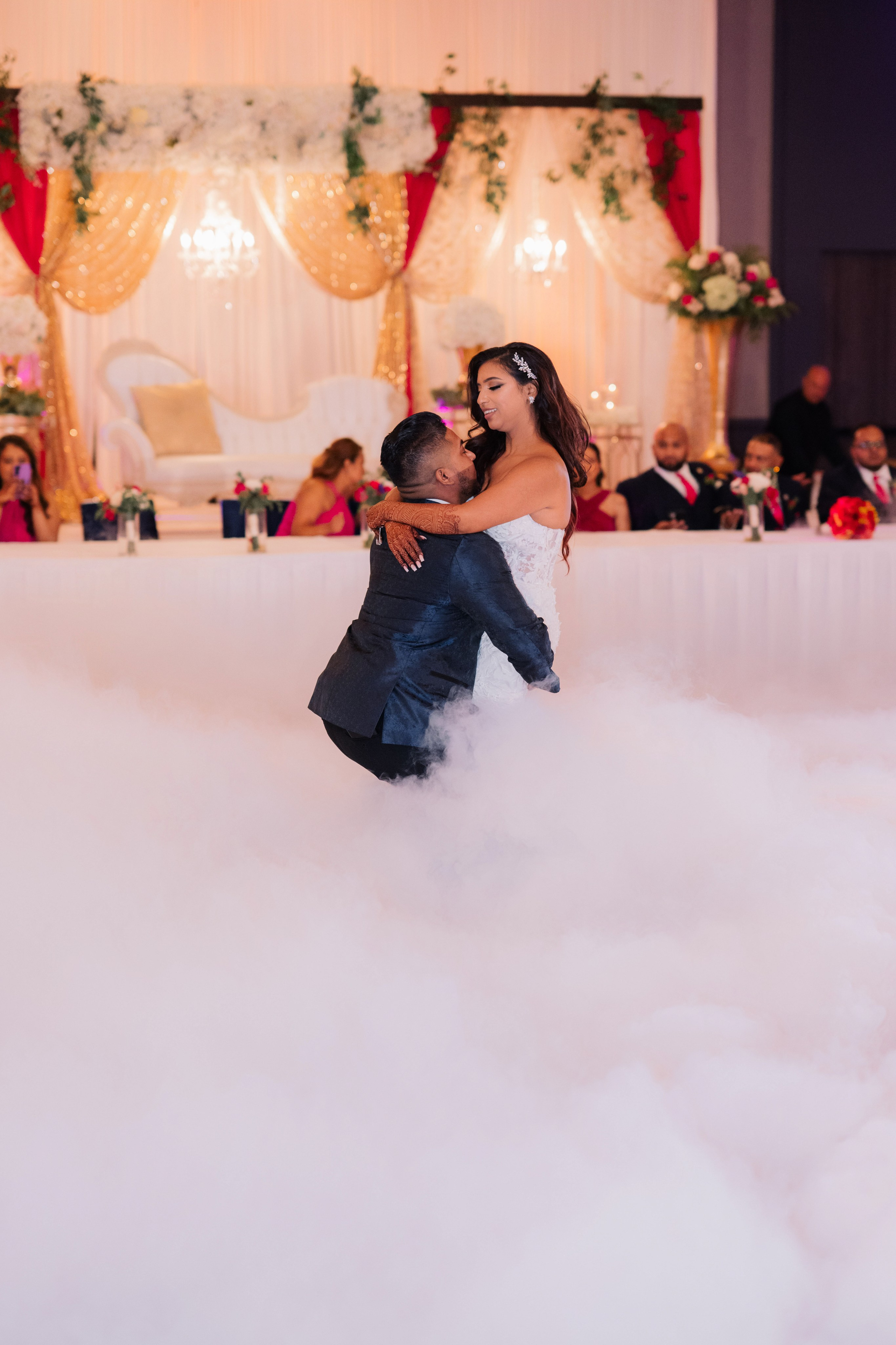 a bride and groom kissing in the clouds