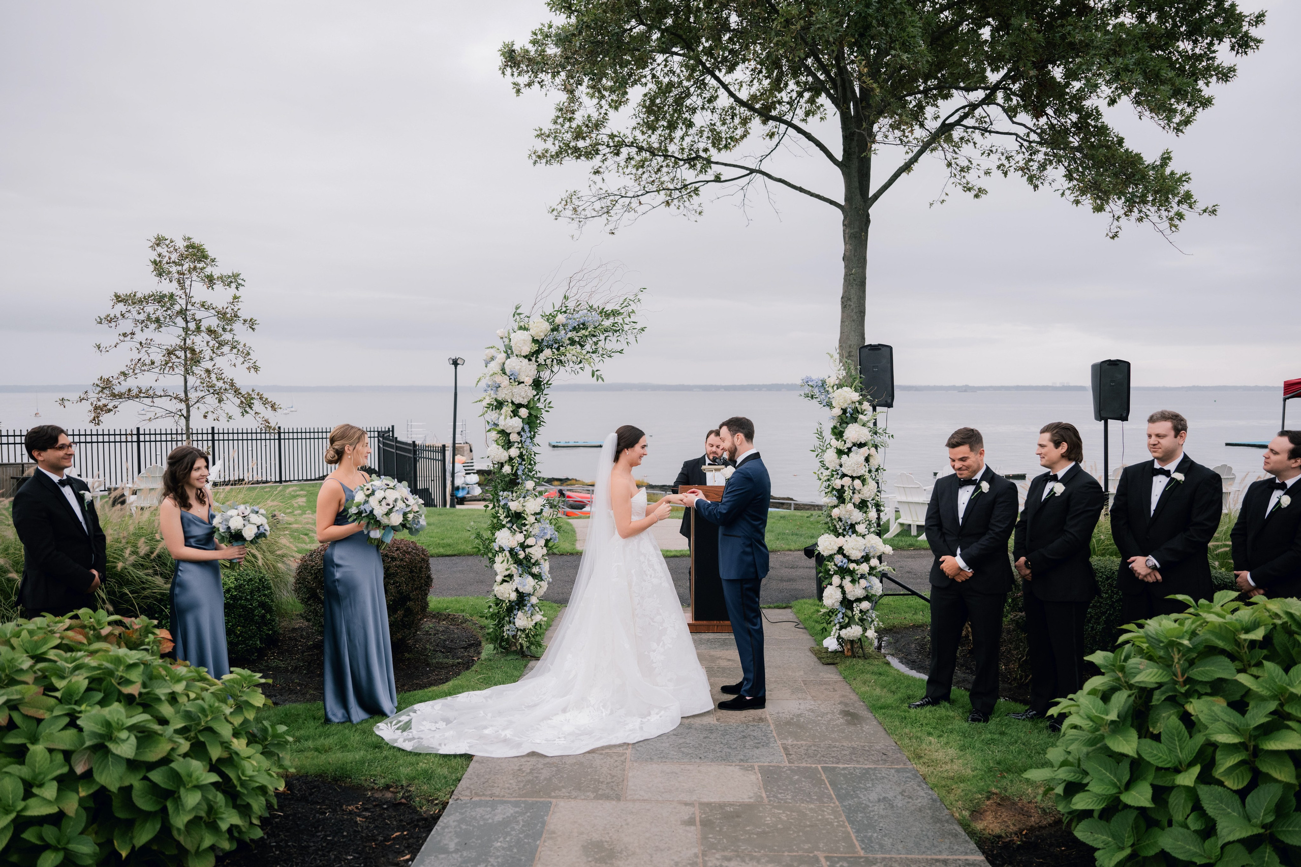 a bride and groom are standing in front of a tree