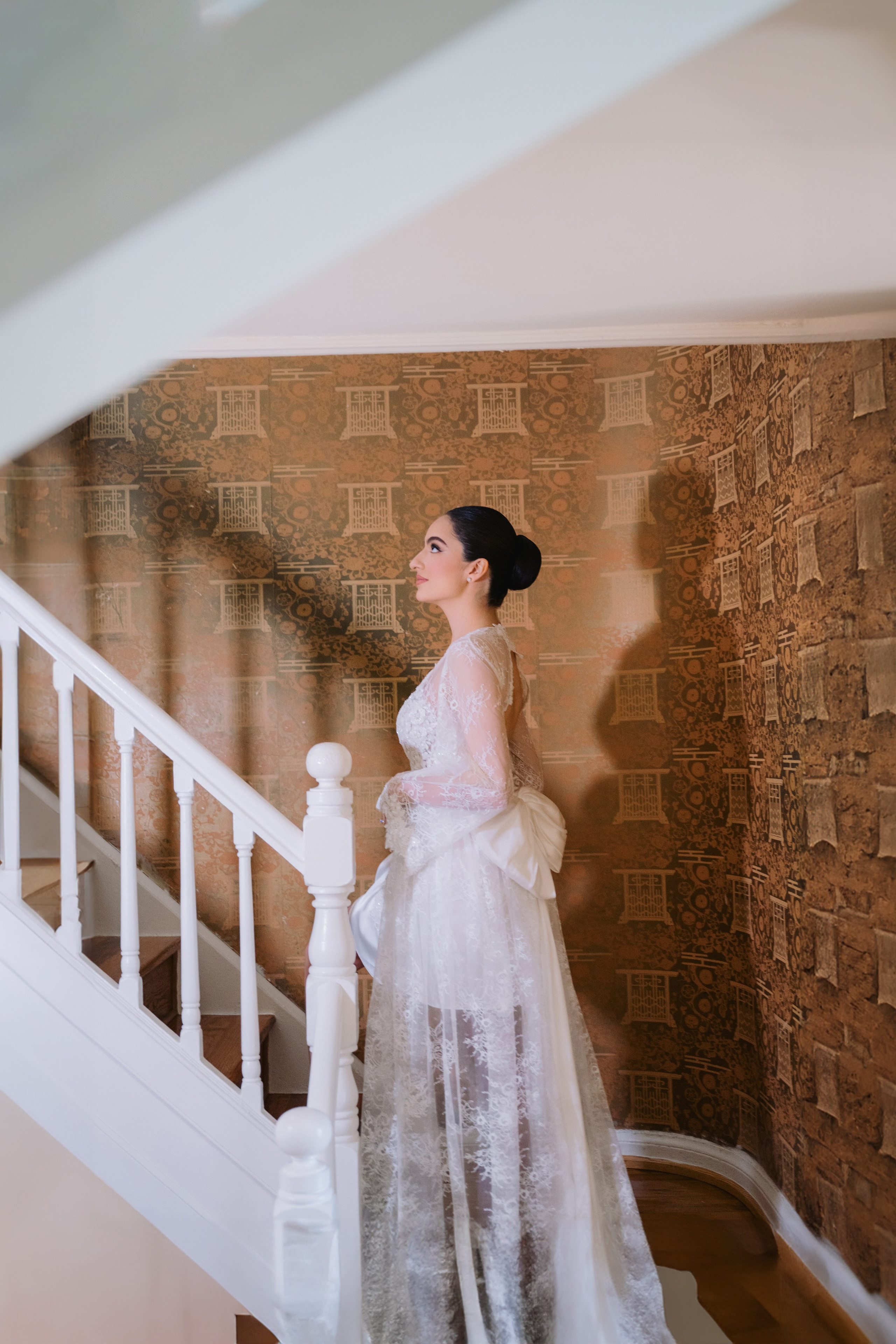a woman in a wedding dress standing on a staircase