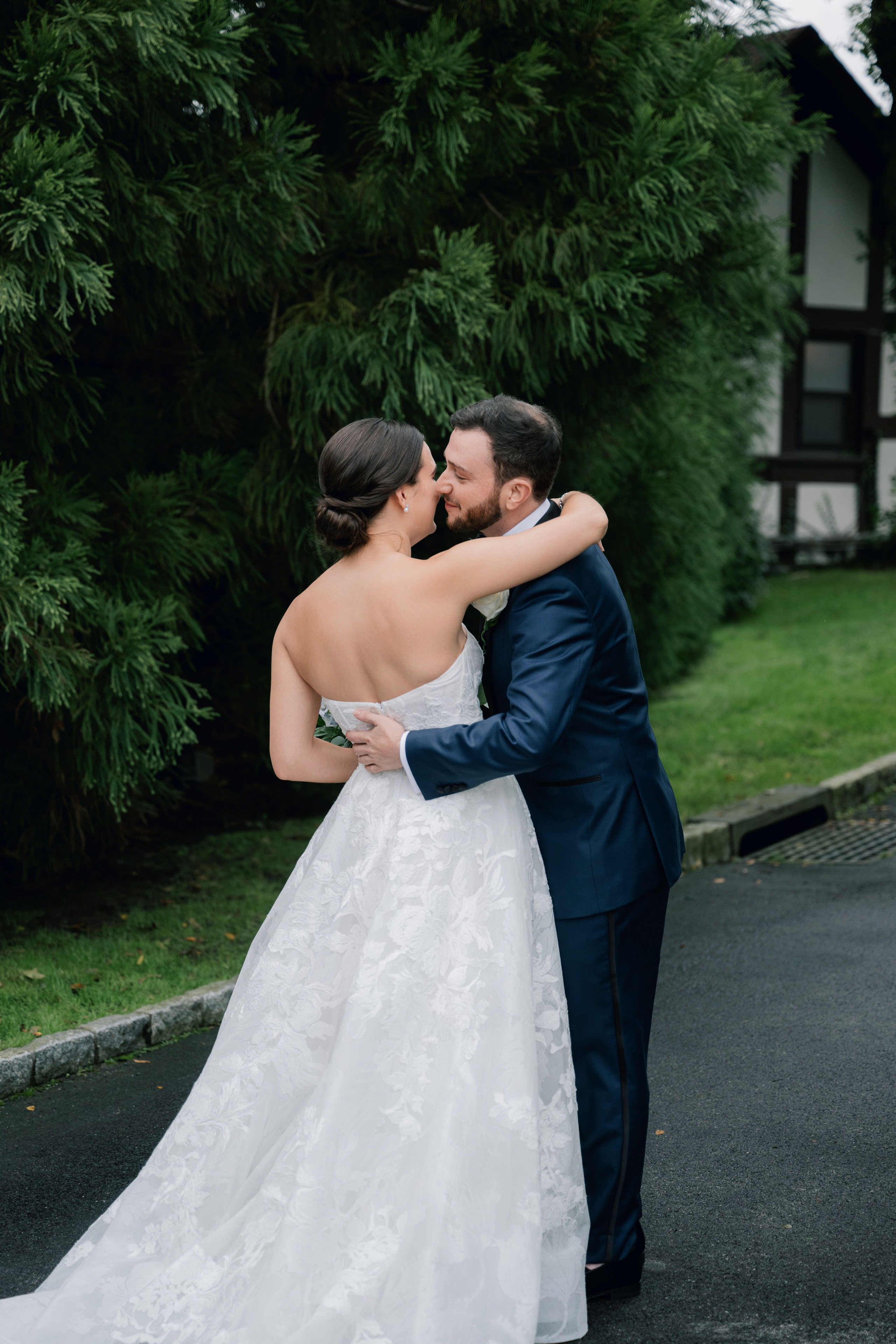 a bride and groom kissing in front of a house