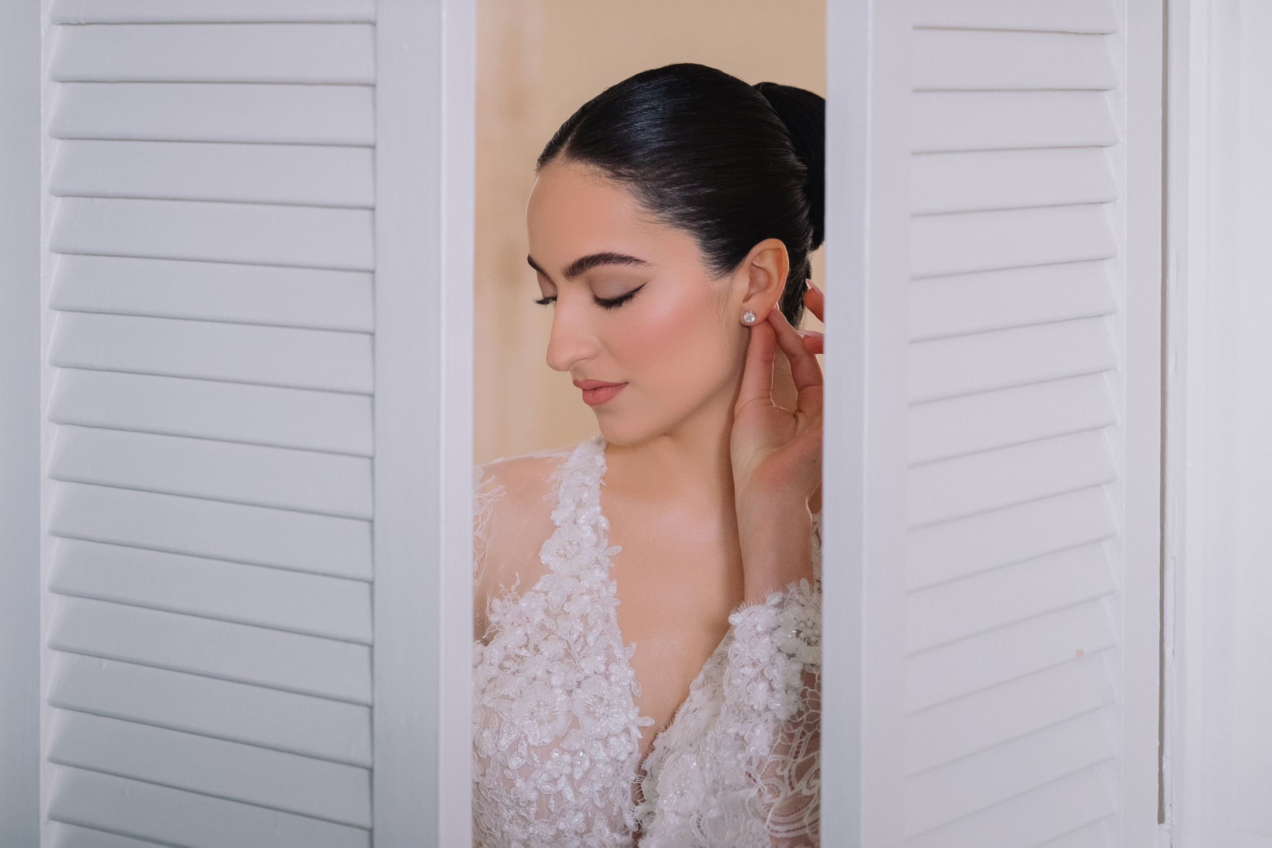 a woman in a white dress looking through a window