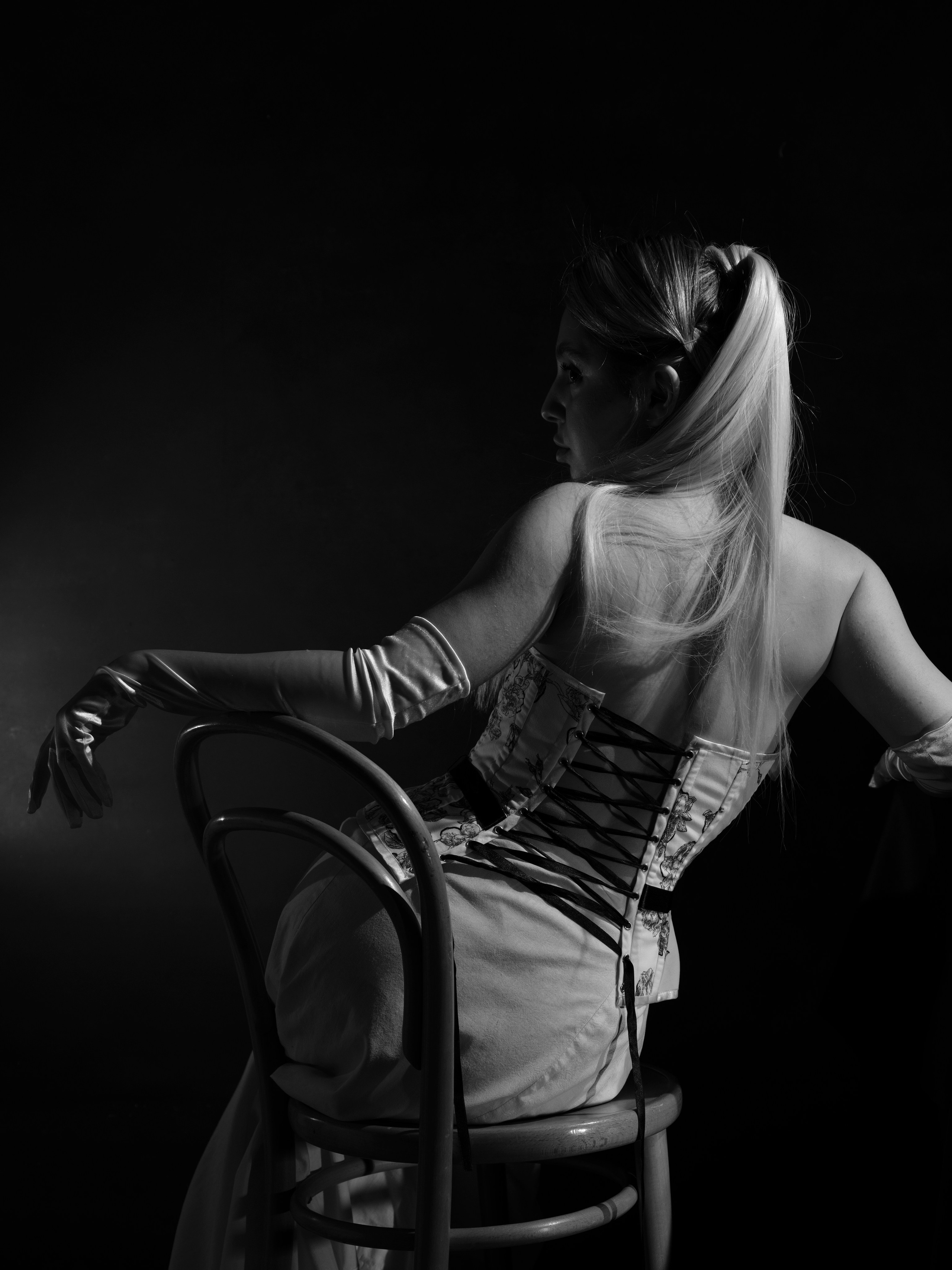Artistic black and white fashion portrait exploring female form, gesture, and movement, photographed in a studio environment.