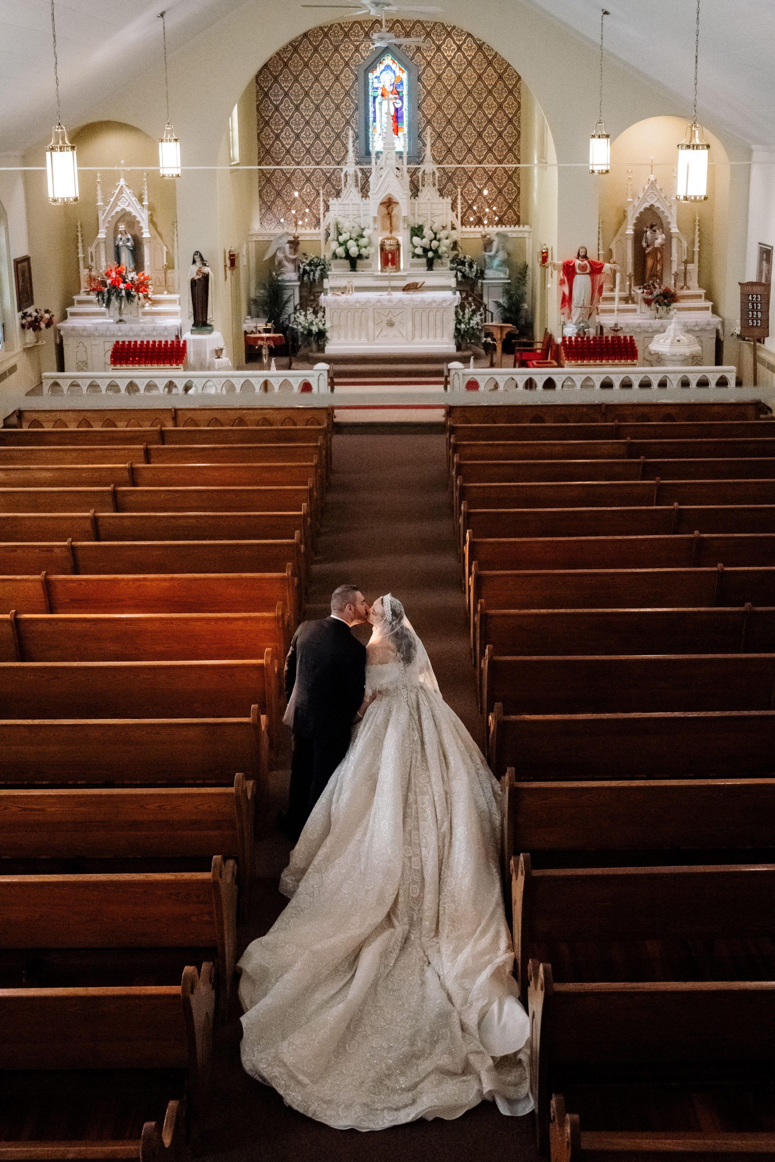 a bride and groom kneeling in a church