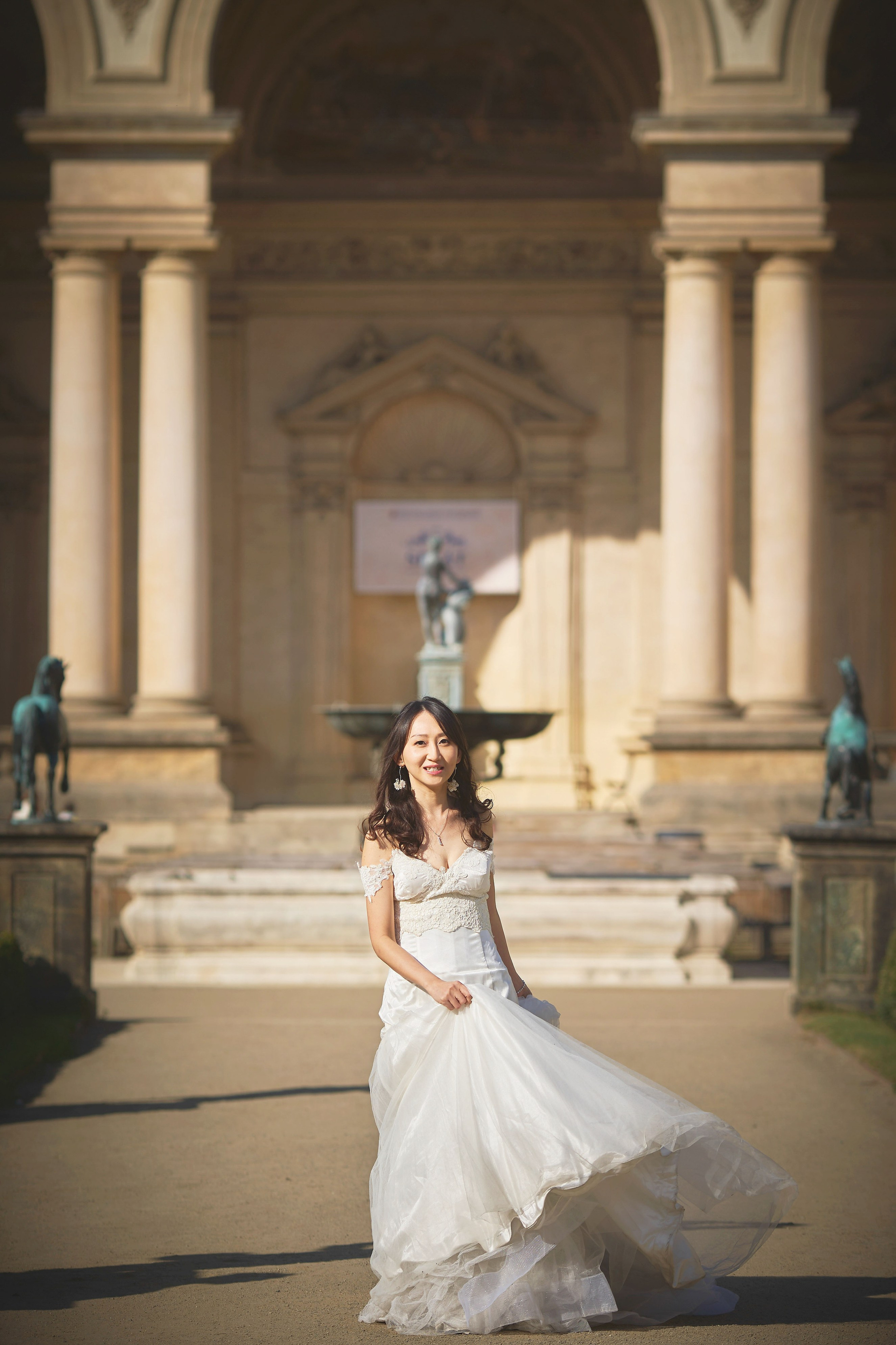 Bride Eva walking gracefully in a wedding dress through Wallenstein Garden, Prague.