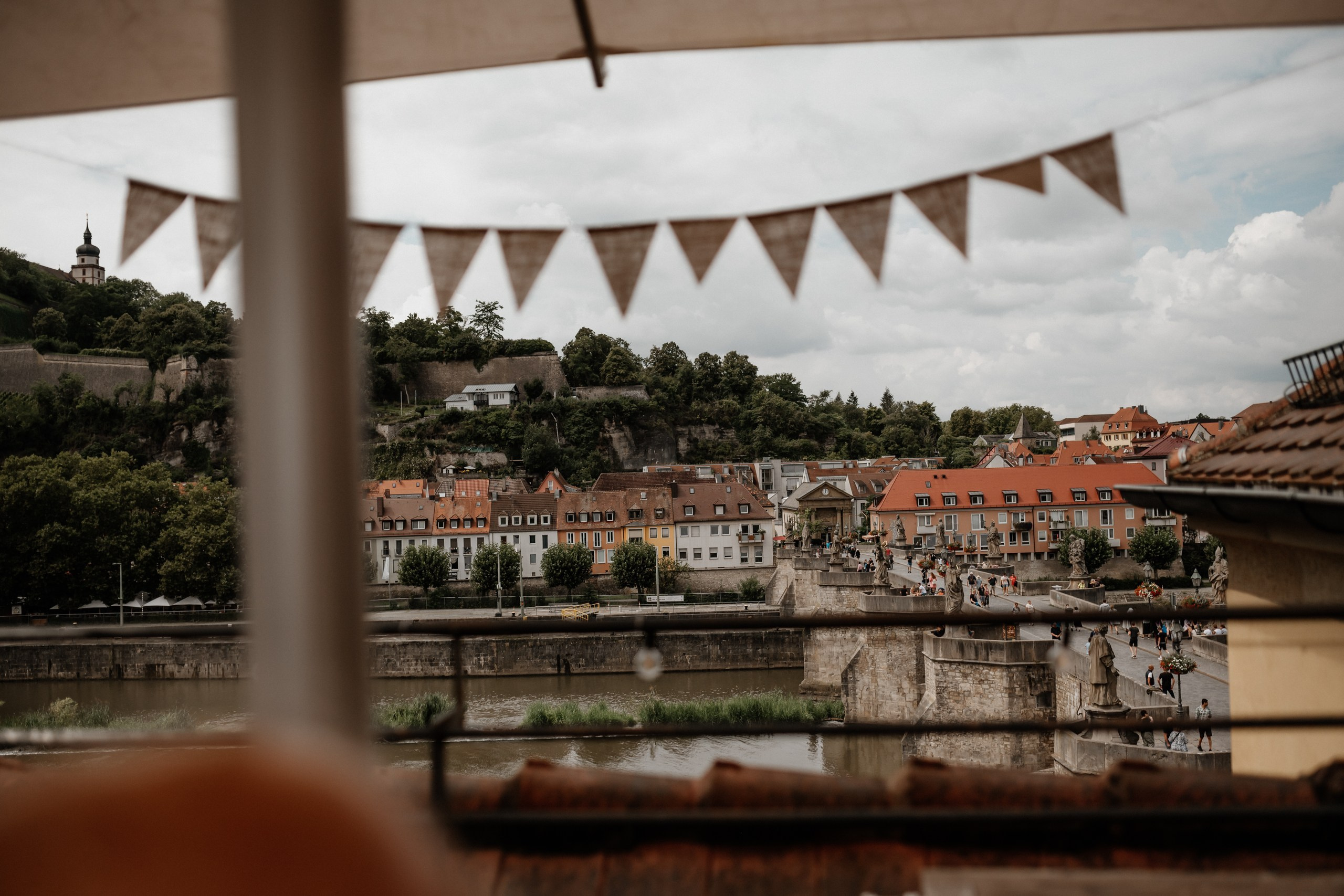 Hochzeitsfoto mit Blick auf die Weinberge von Würzburg von der Alten Mainbrücke aus