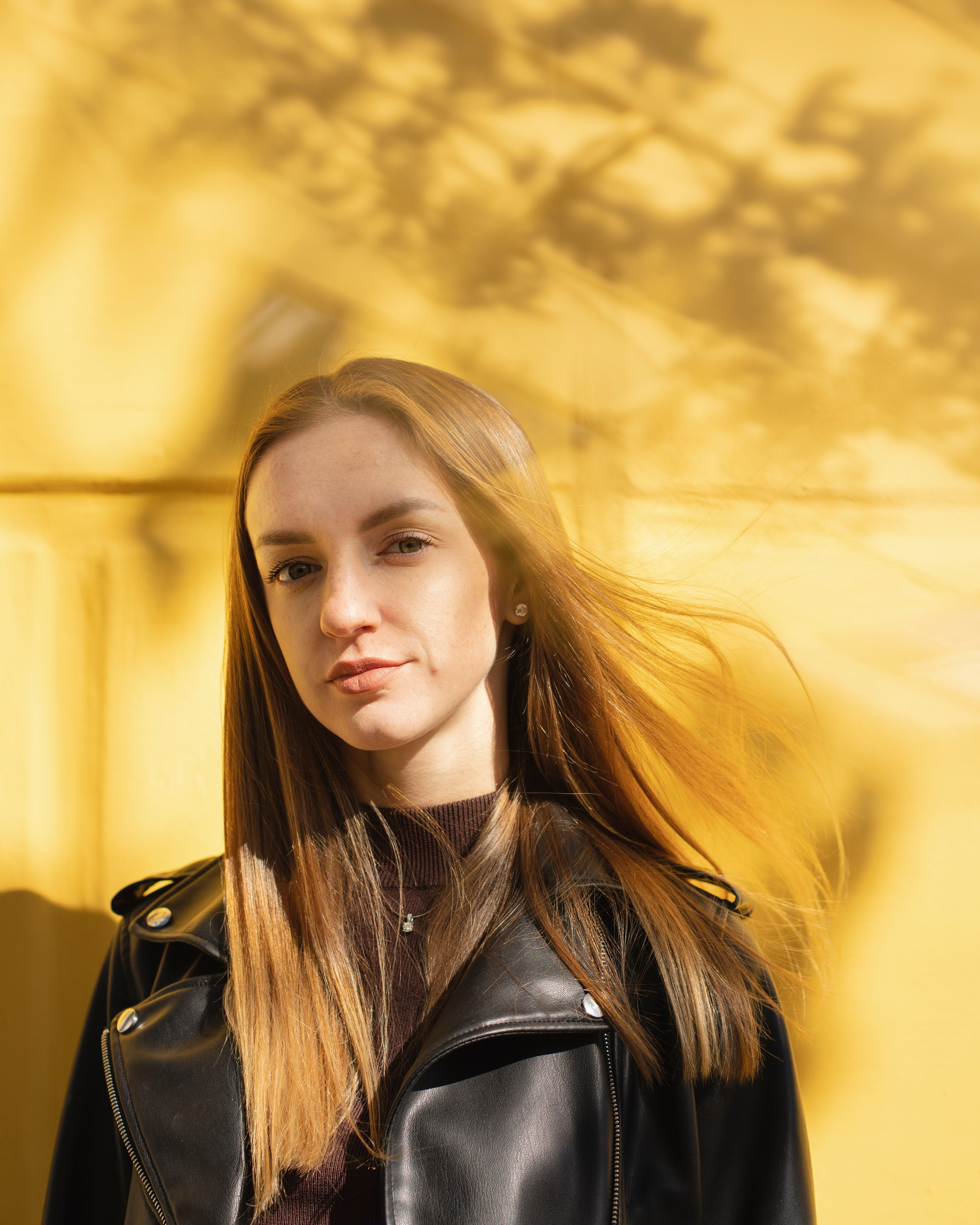 Portrait of a woman standing against a yellow wall