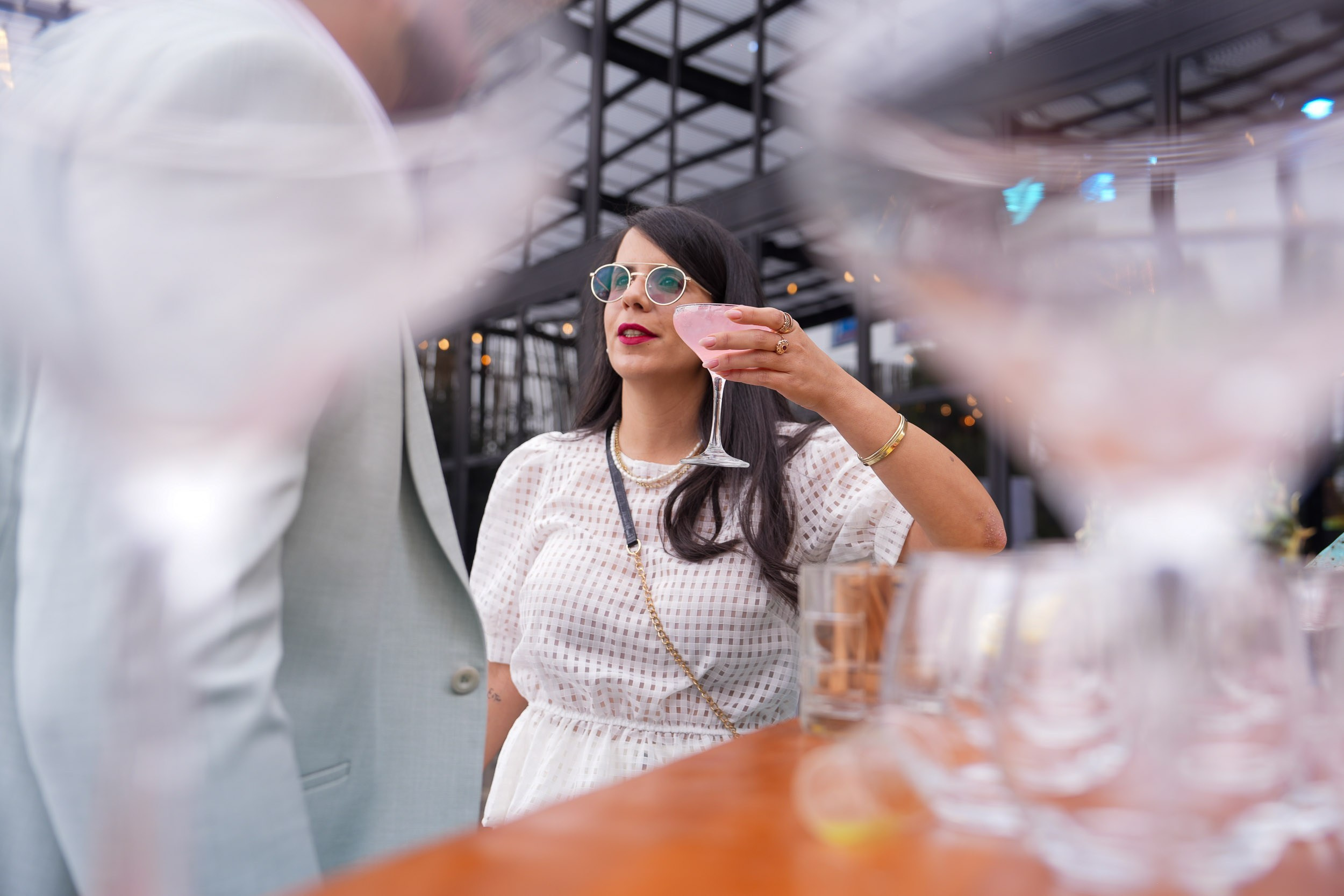 A woman raises a small glass during the wedding reception