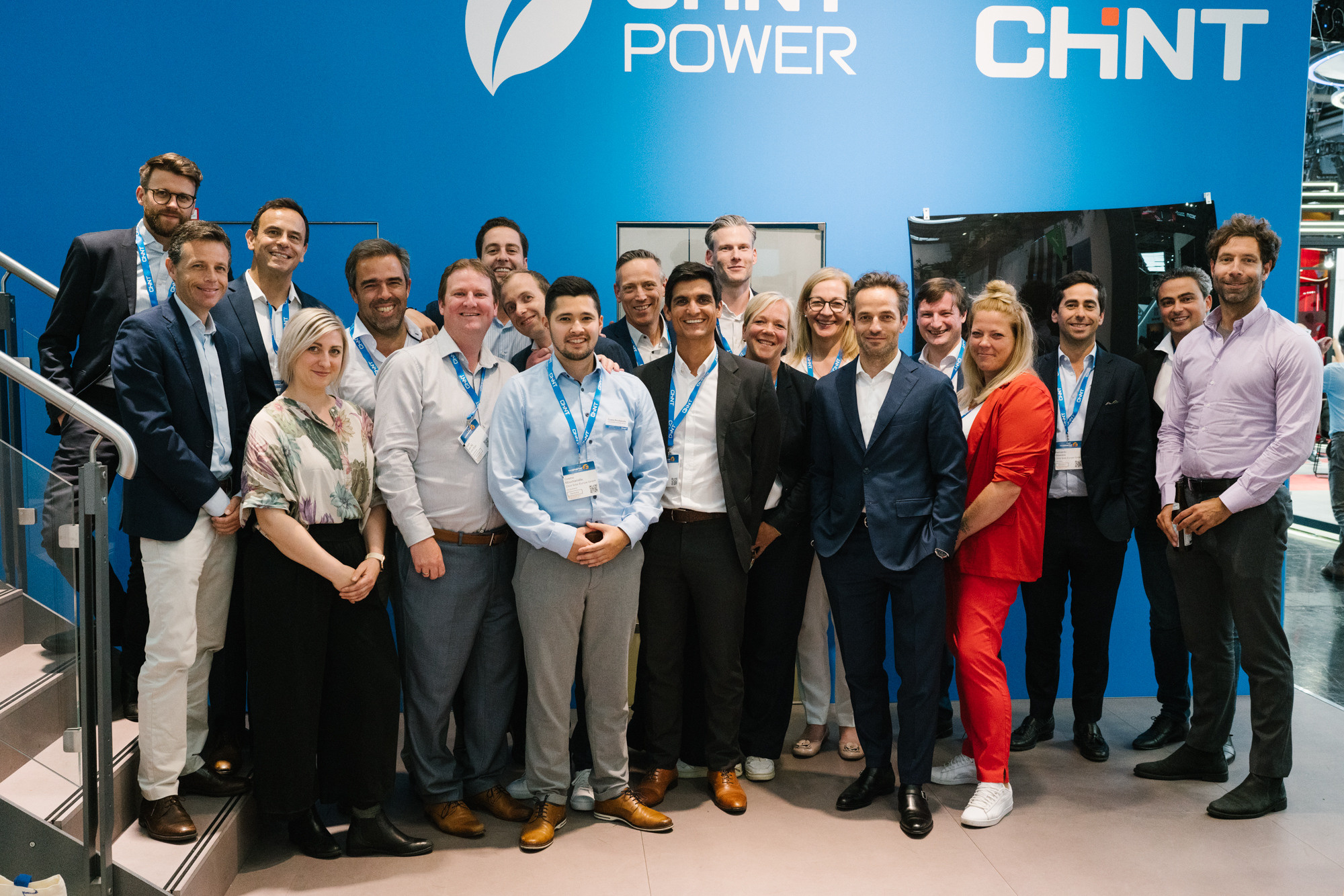 Lächelndes Team posiert für ein Gruppenfoto am Messestand der Messe München