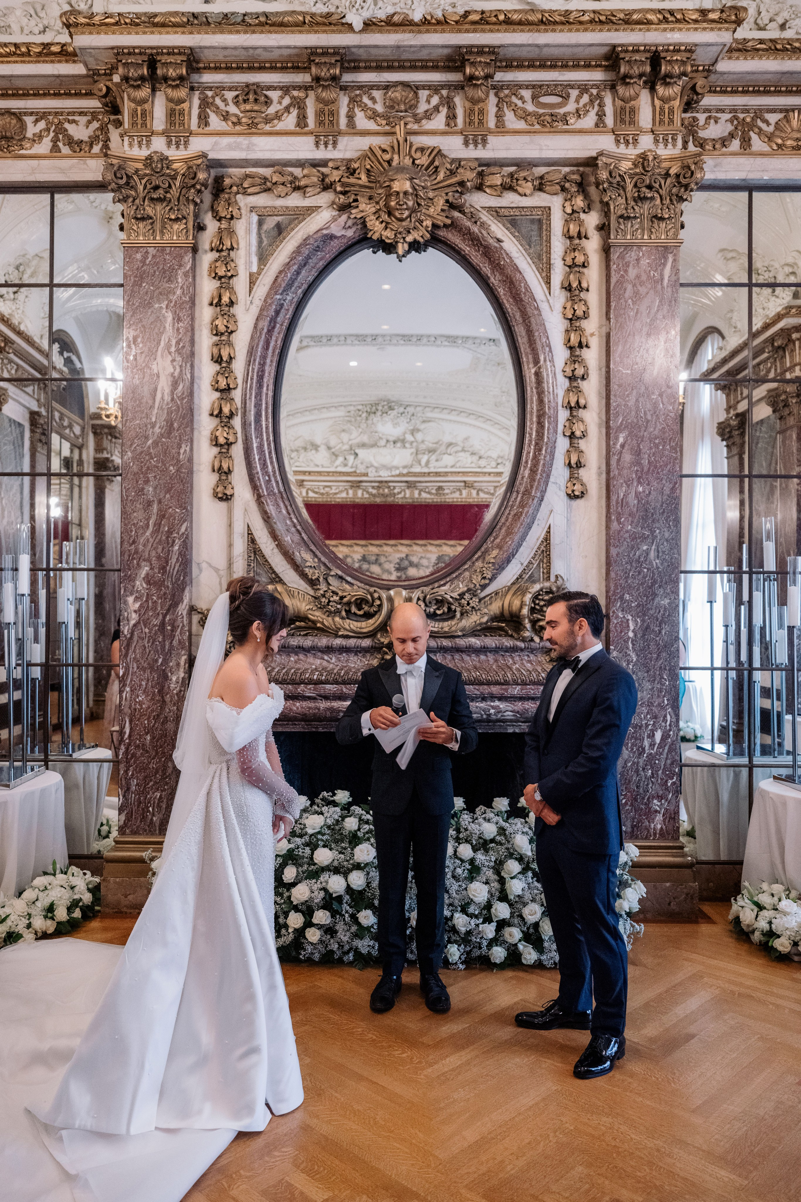 a bride and groom are standing in front of a mirror