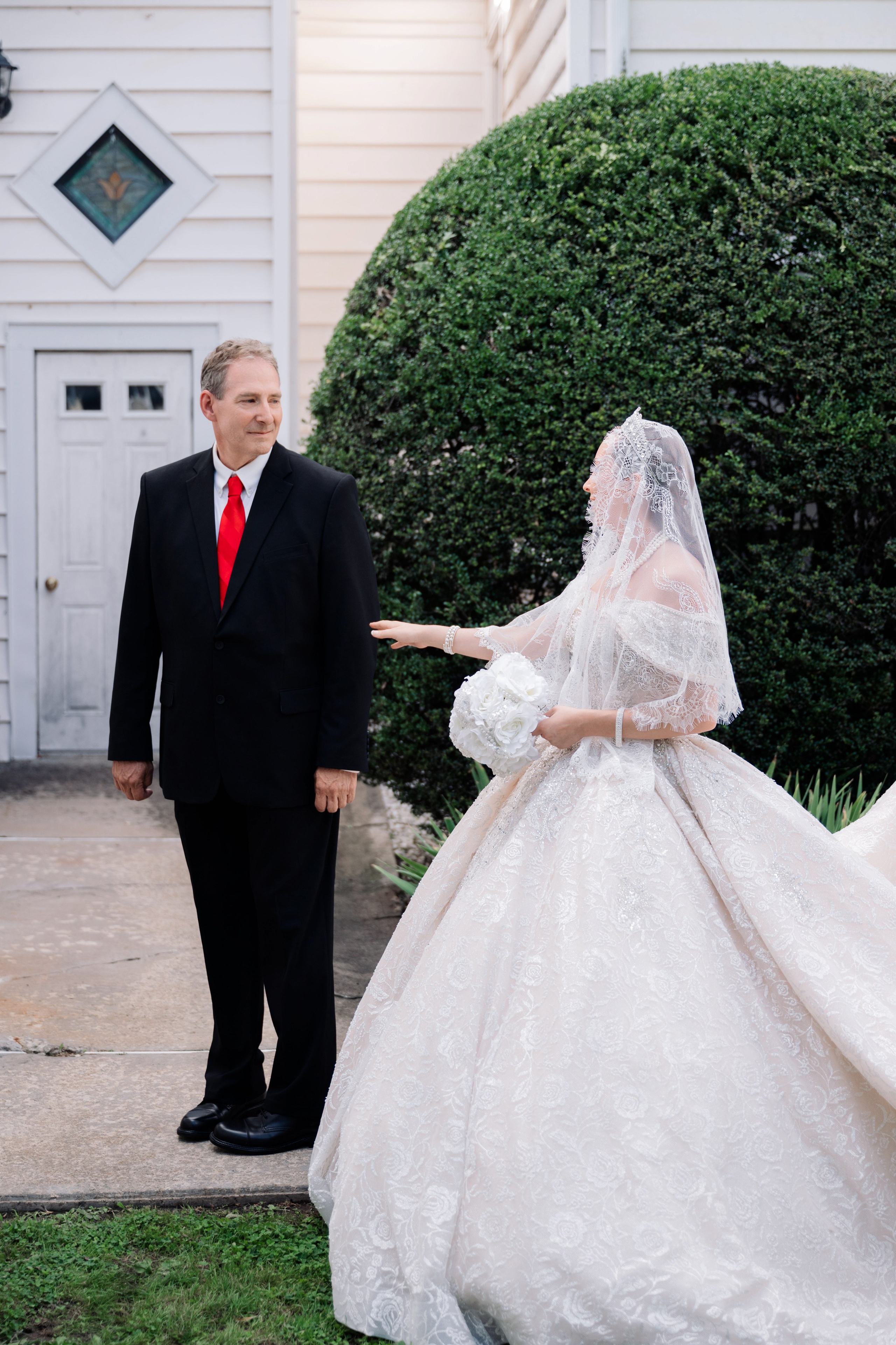a bride and groom are standing in front of a house