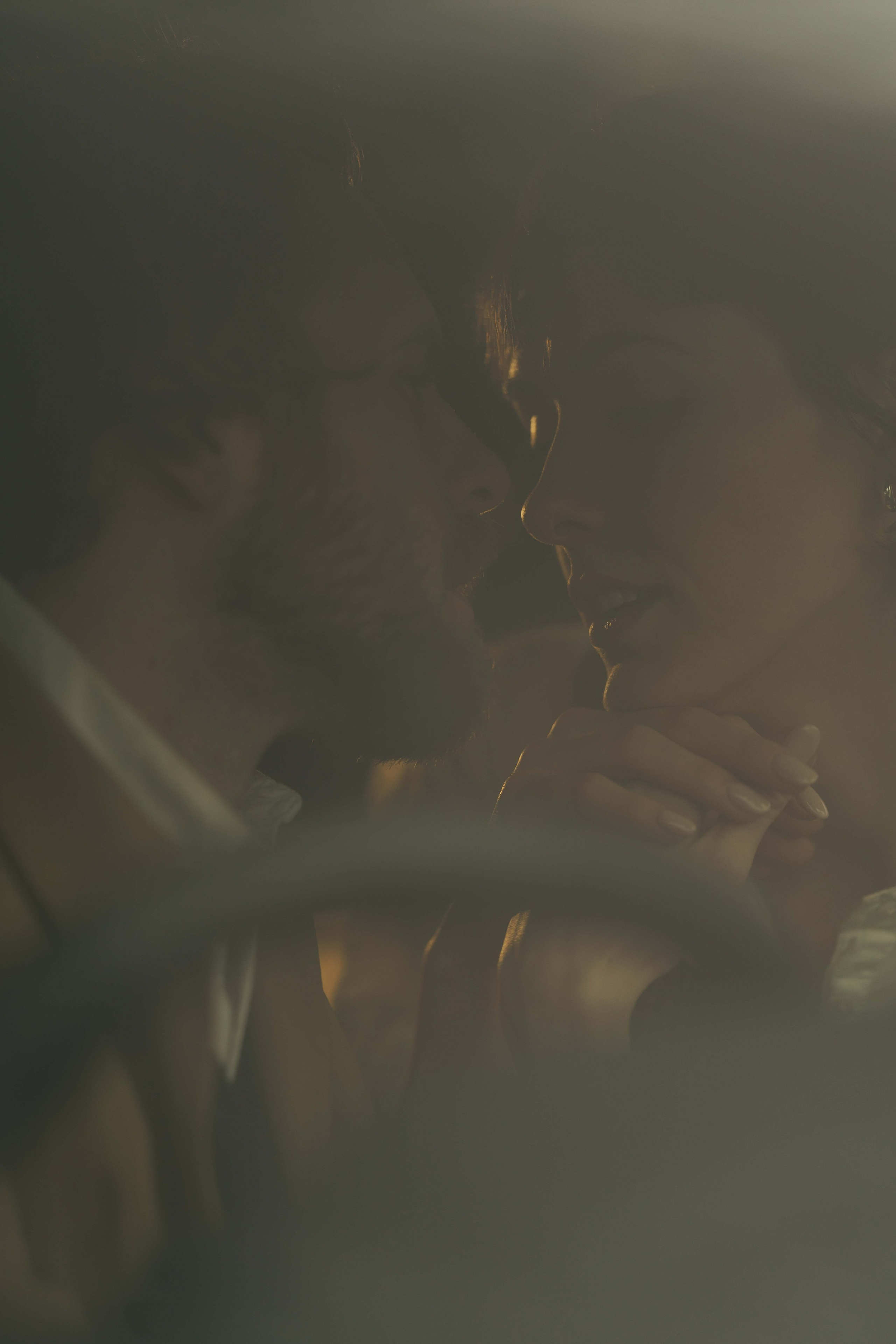 couple seen through window in the car with reflections and warm cinematic light Cotswolds