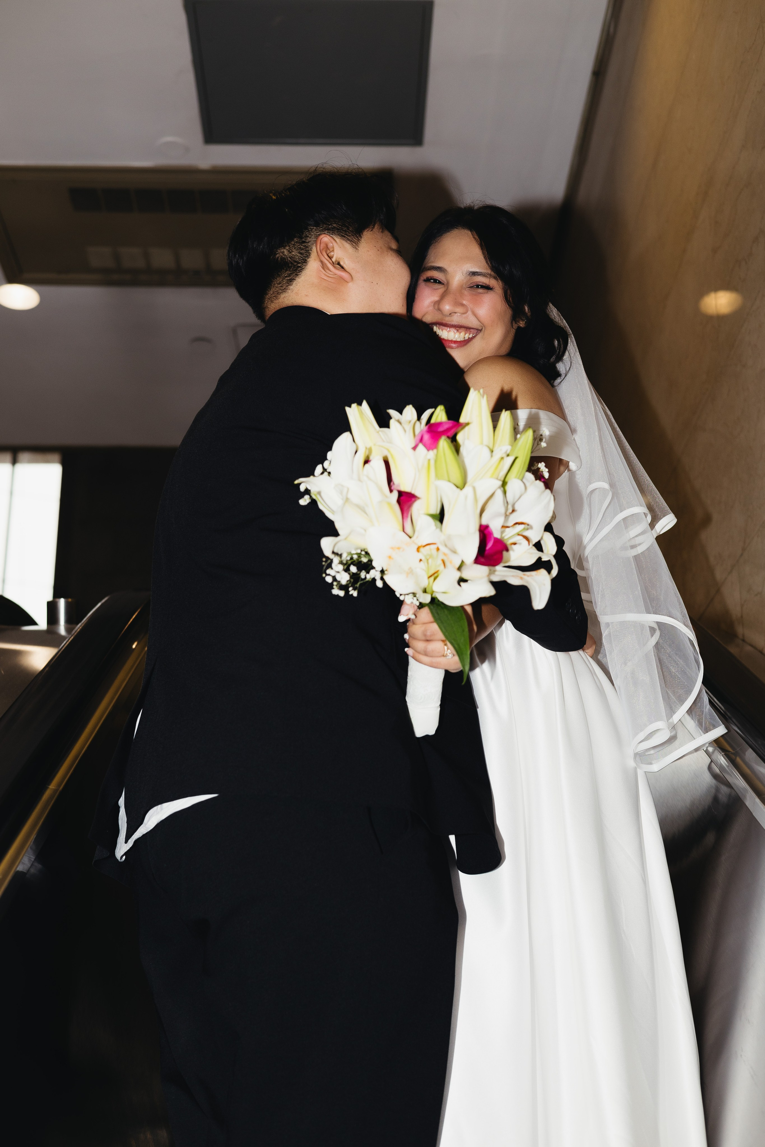 Couple riding an escalator inside Chicago City Hall after their ceremony