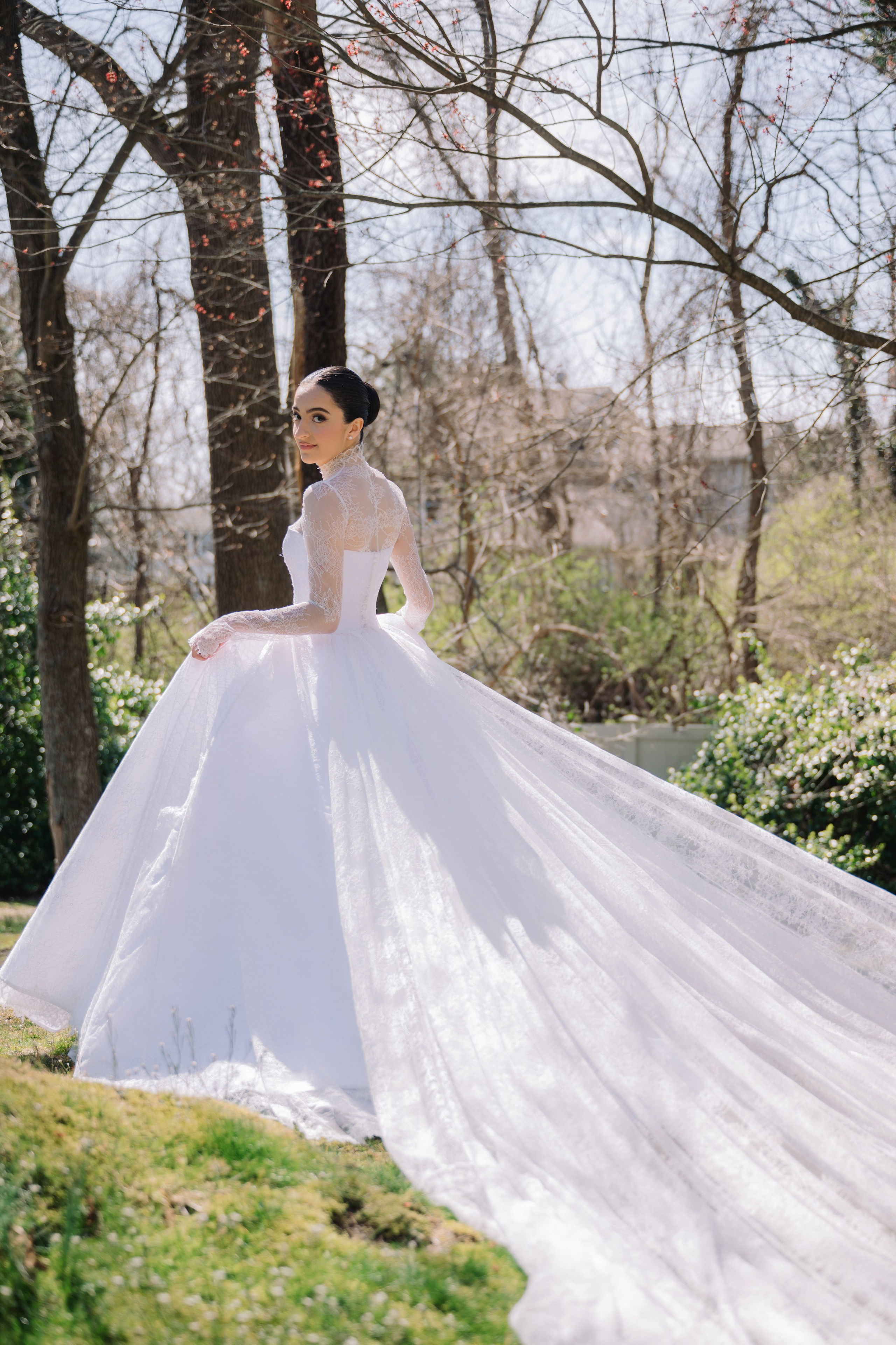 a woman in a white wedding dress standing in the grass