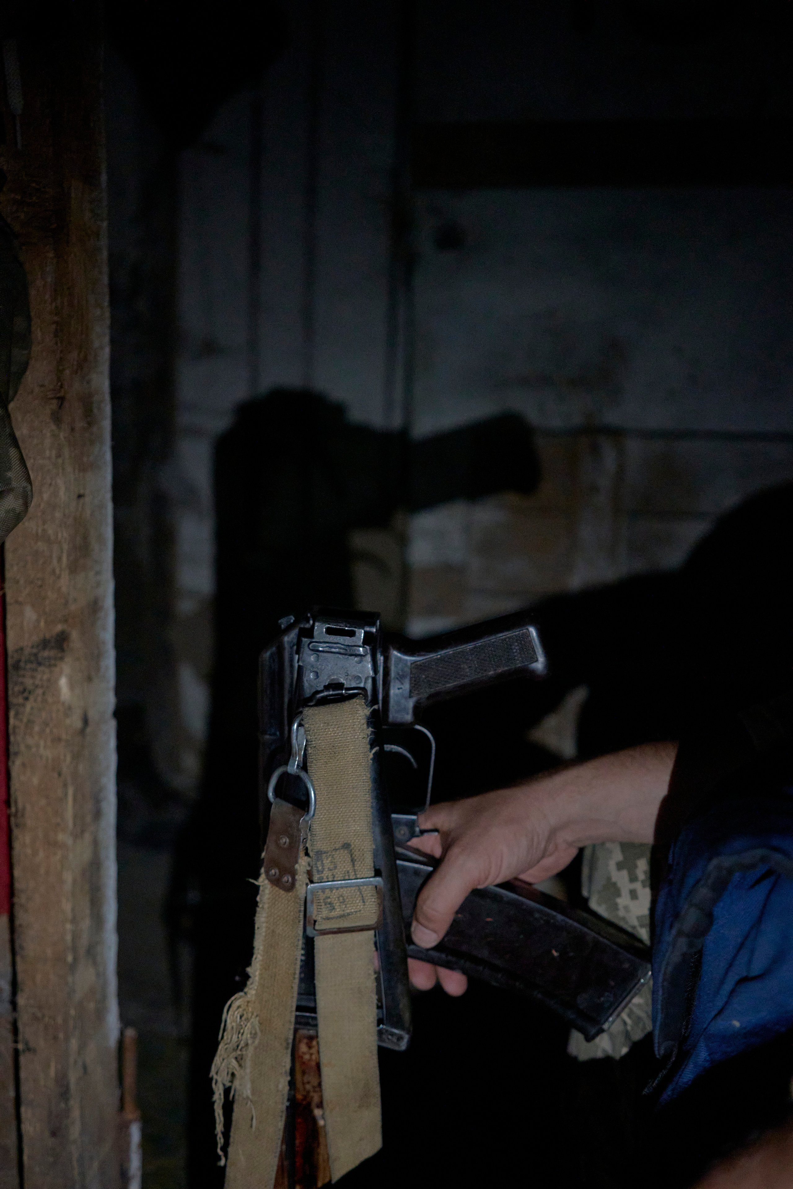 Hand of a soldier with Kalashnikov rifle in the shelter.