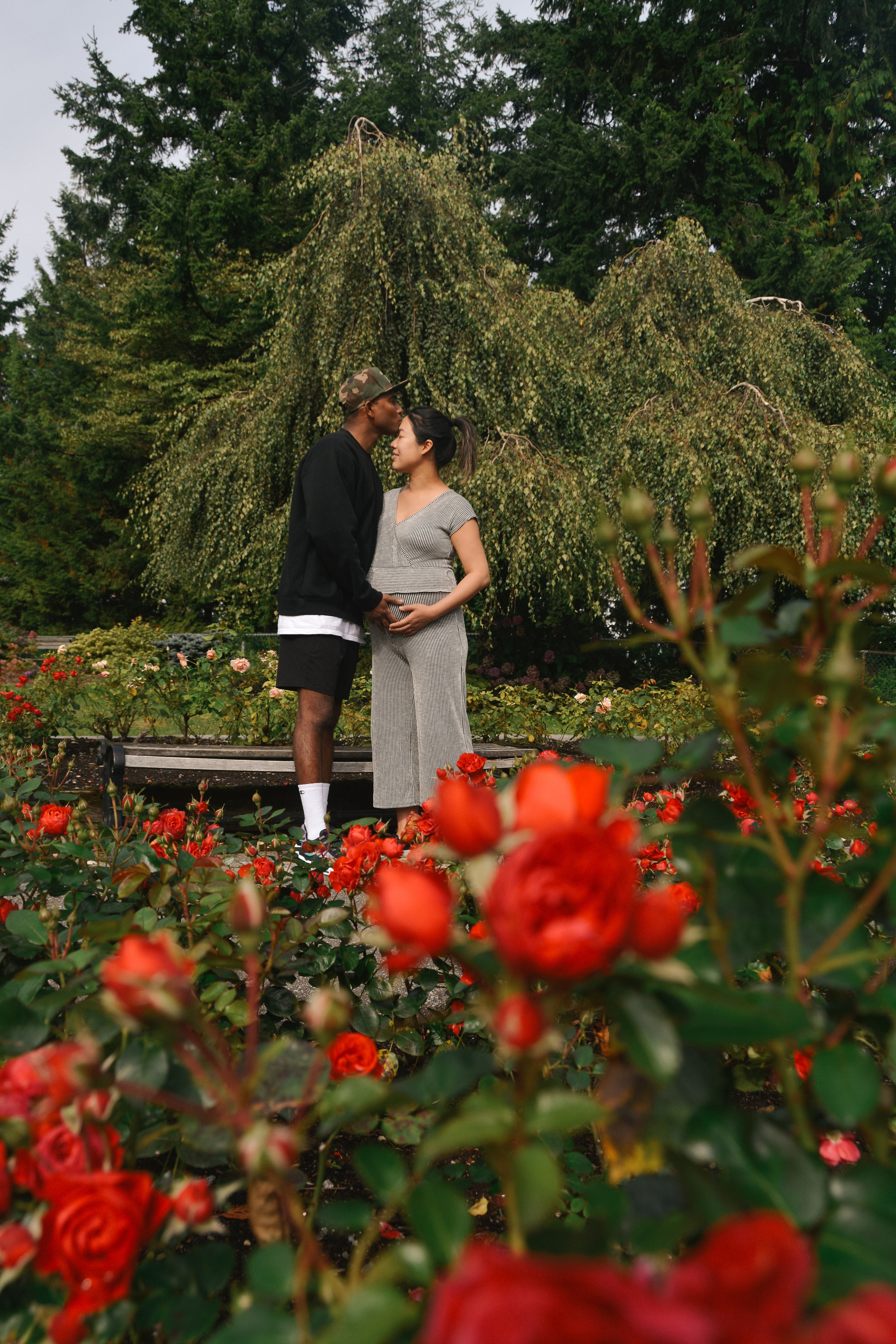 Couple kissing in the garden standing among beautiful roses in Burnaby