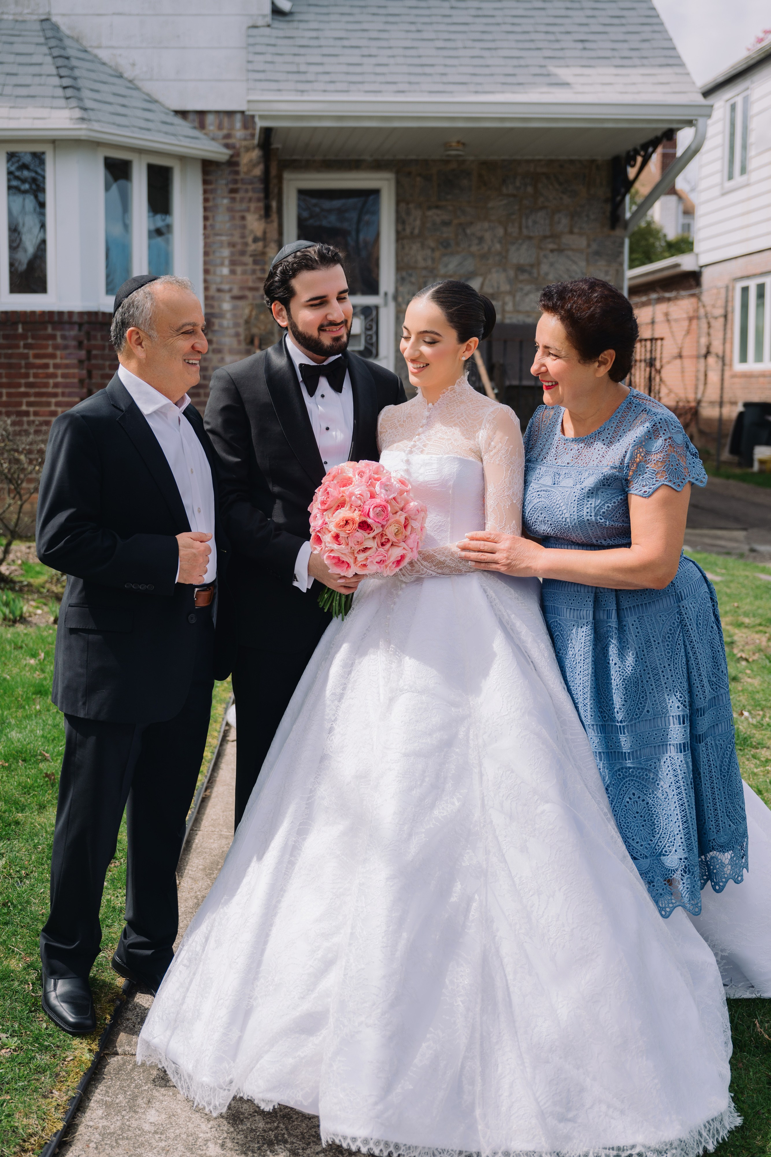 a bride and groom are standing in front of a house