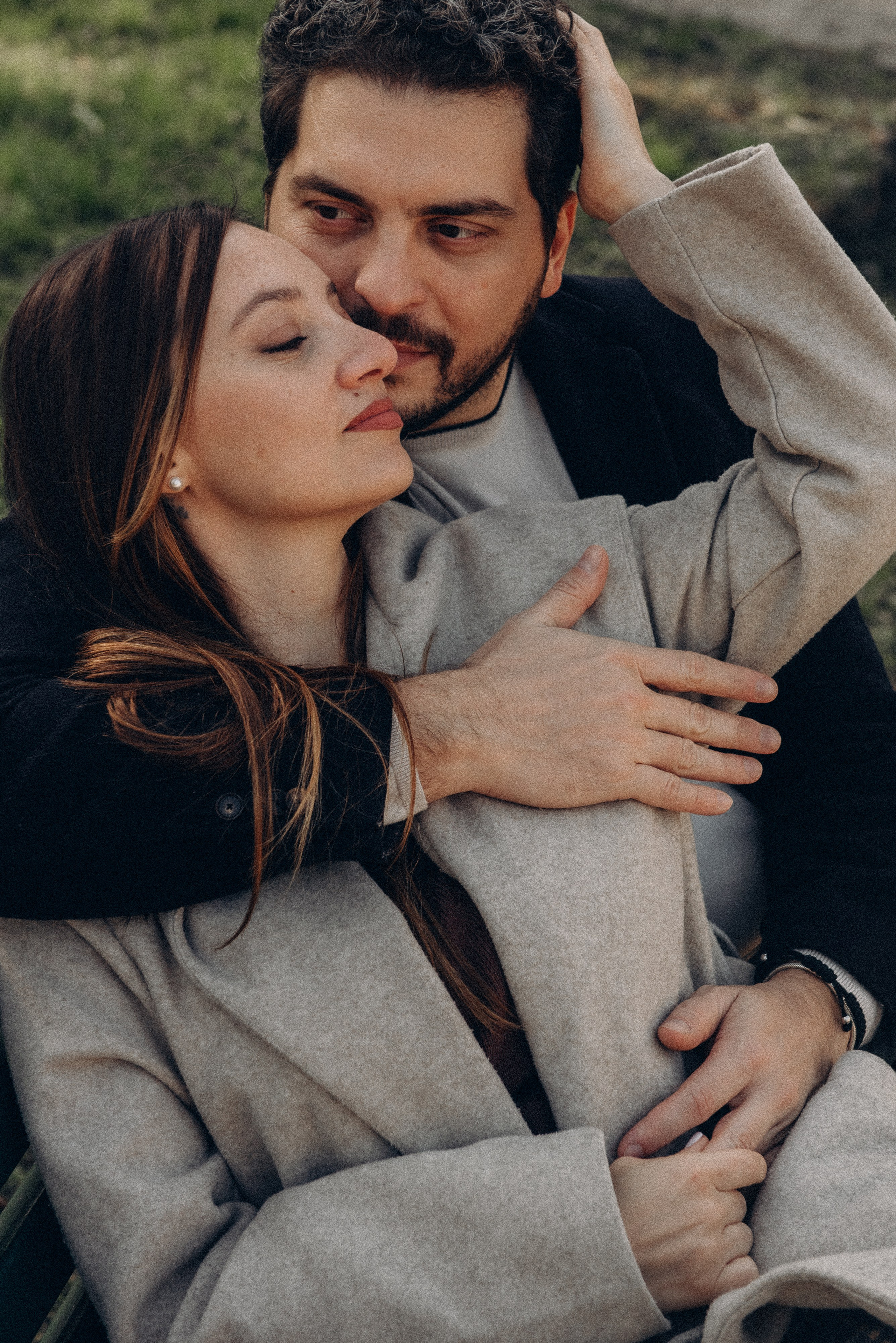 Couple sitting closely together, enjoying a tender moment in a park in Milan. Couple photographer in Milan.