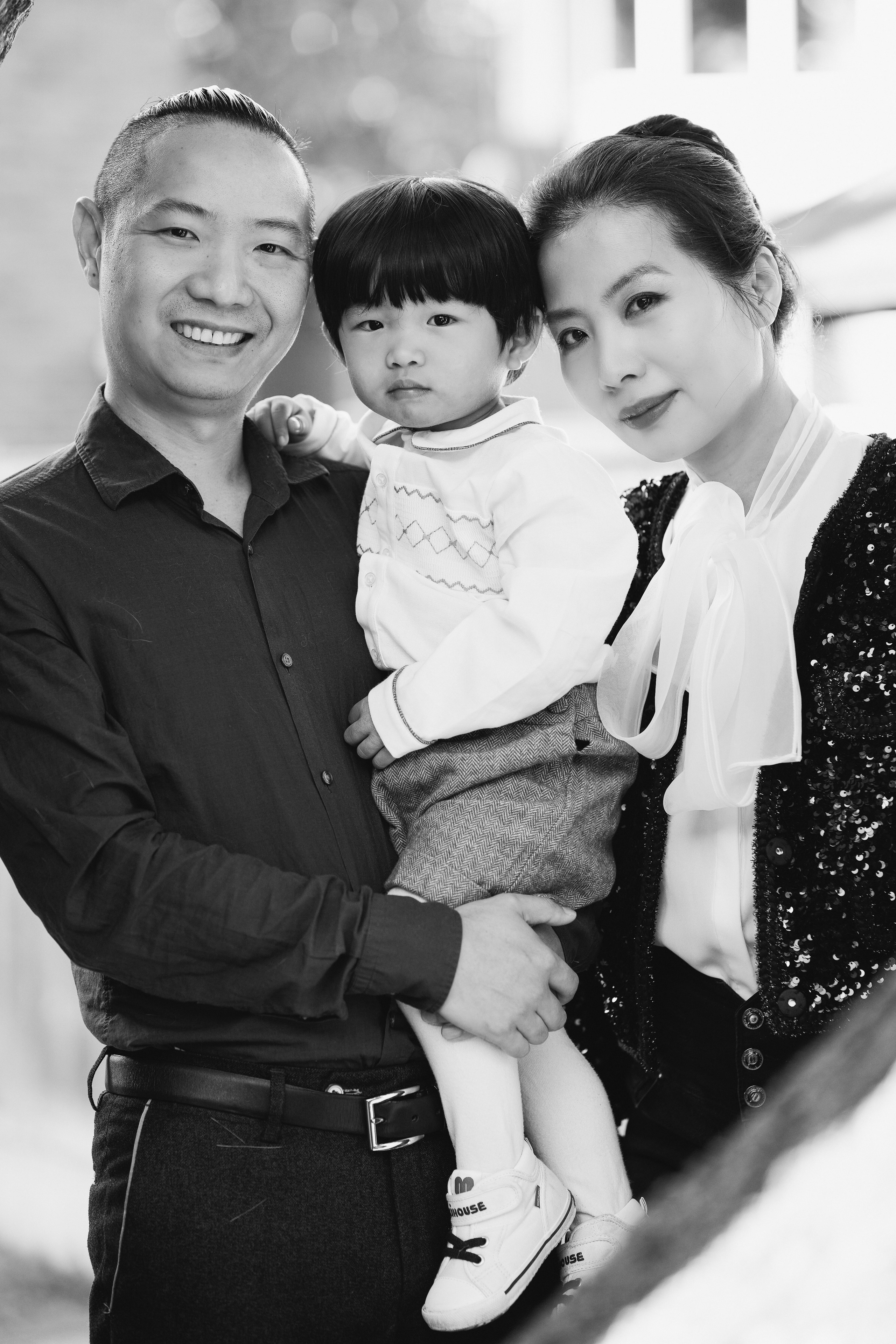 Black and white family portrait of parents holding their young child during a lifestyle session