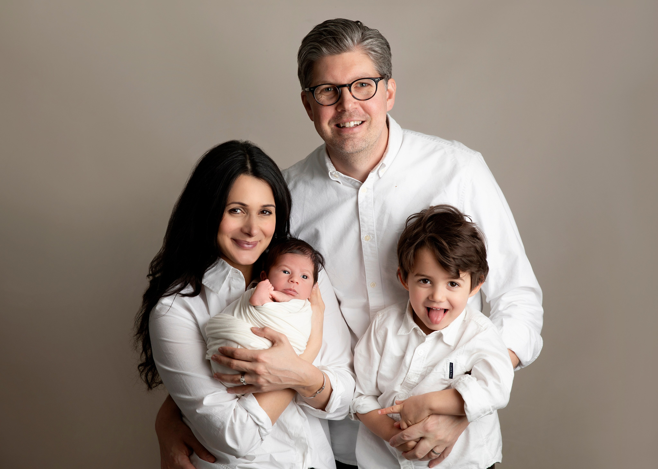 "En varm och kärleksfull familjefotografi med nyfödda tvillingar och deras äldre bror eller syster. Bilden fångar glädjen och stoltheten i att vara en del av en utökad familj."