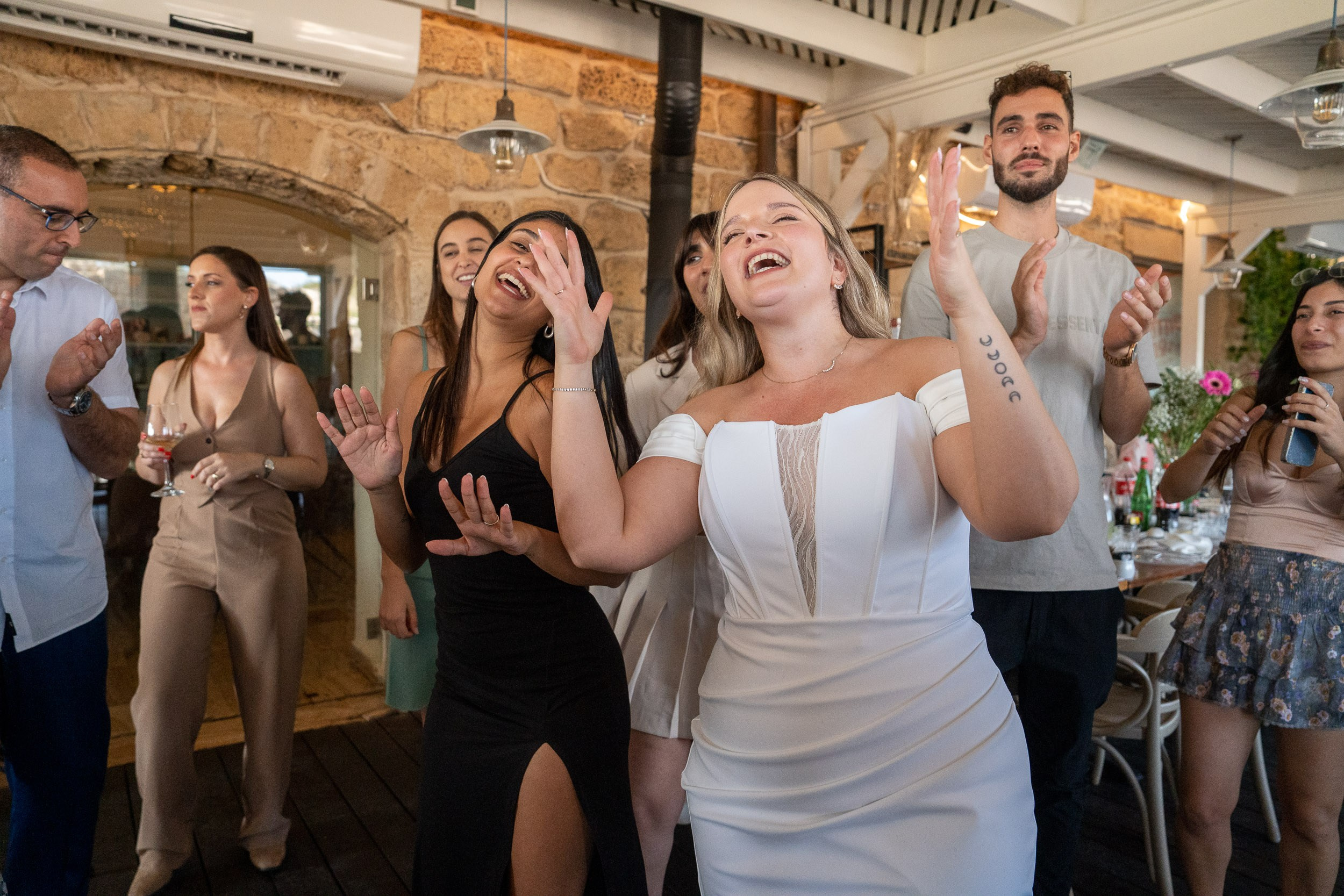 Yael laughs and dances with guests during the reception