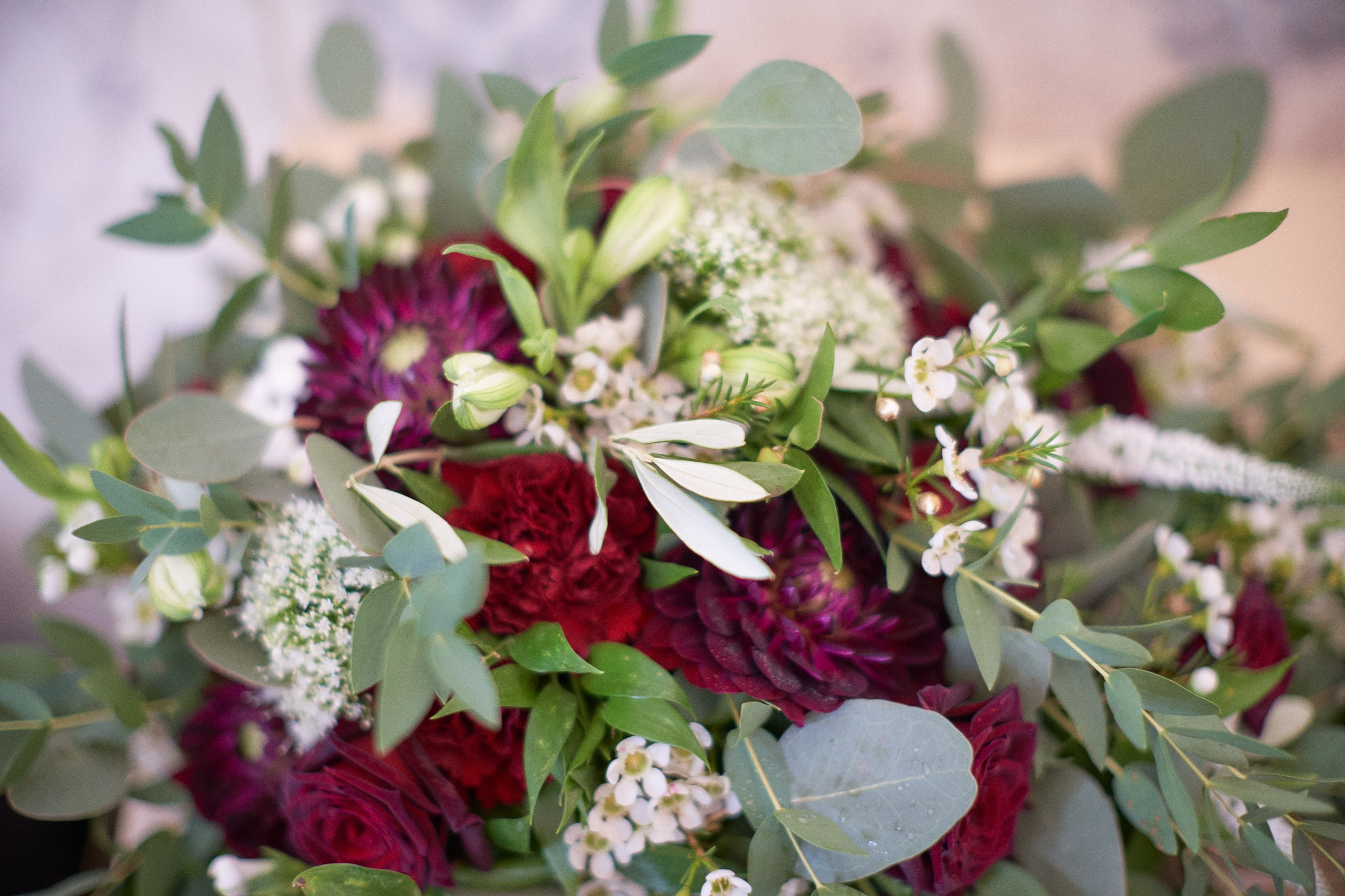 Dramatic red and black bridal bouquet in luxurious Prague getting-ready suite.