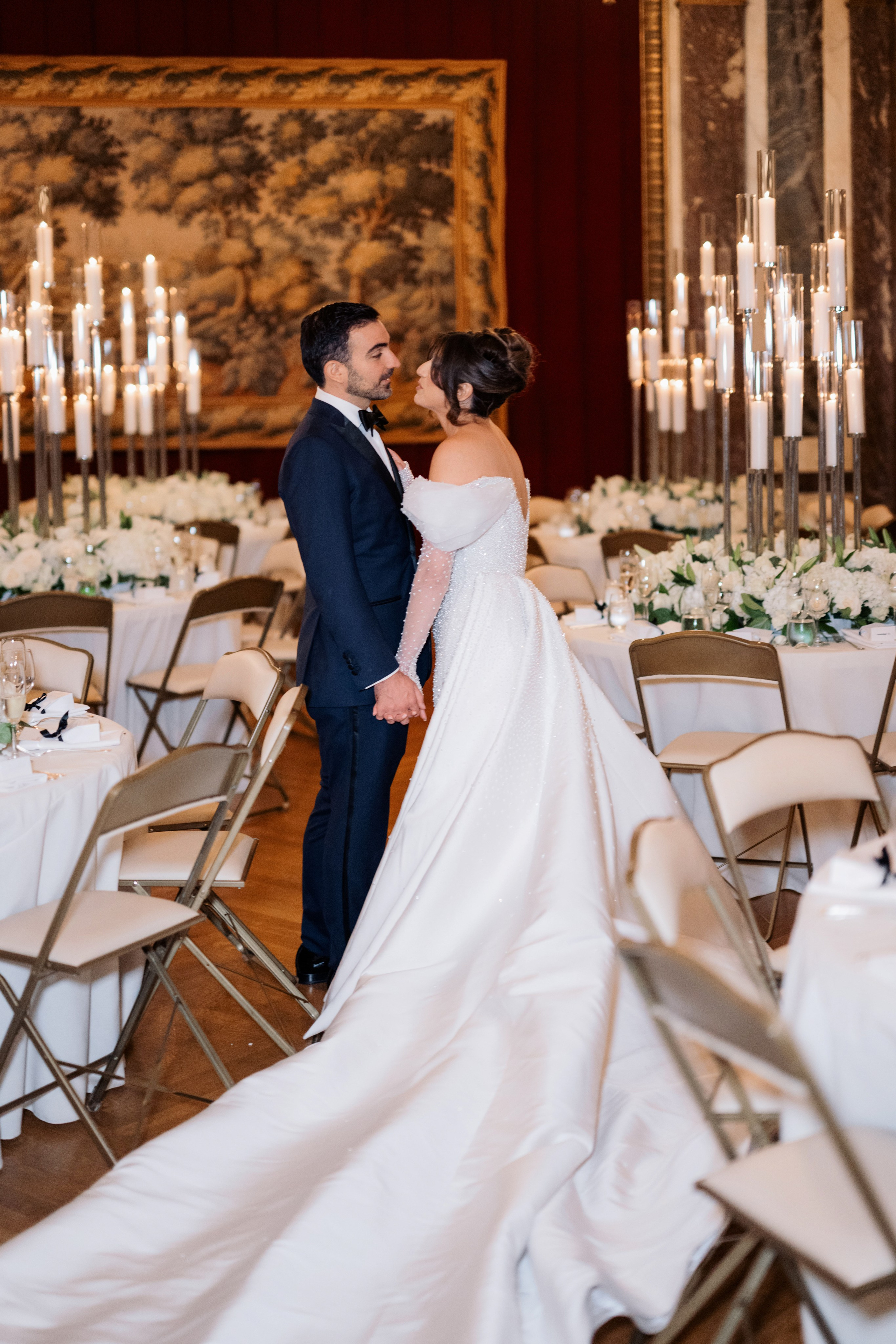 a bride and groom kissing in a ballroom