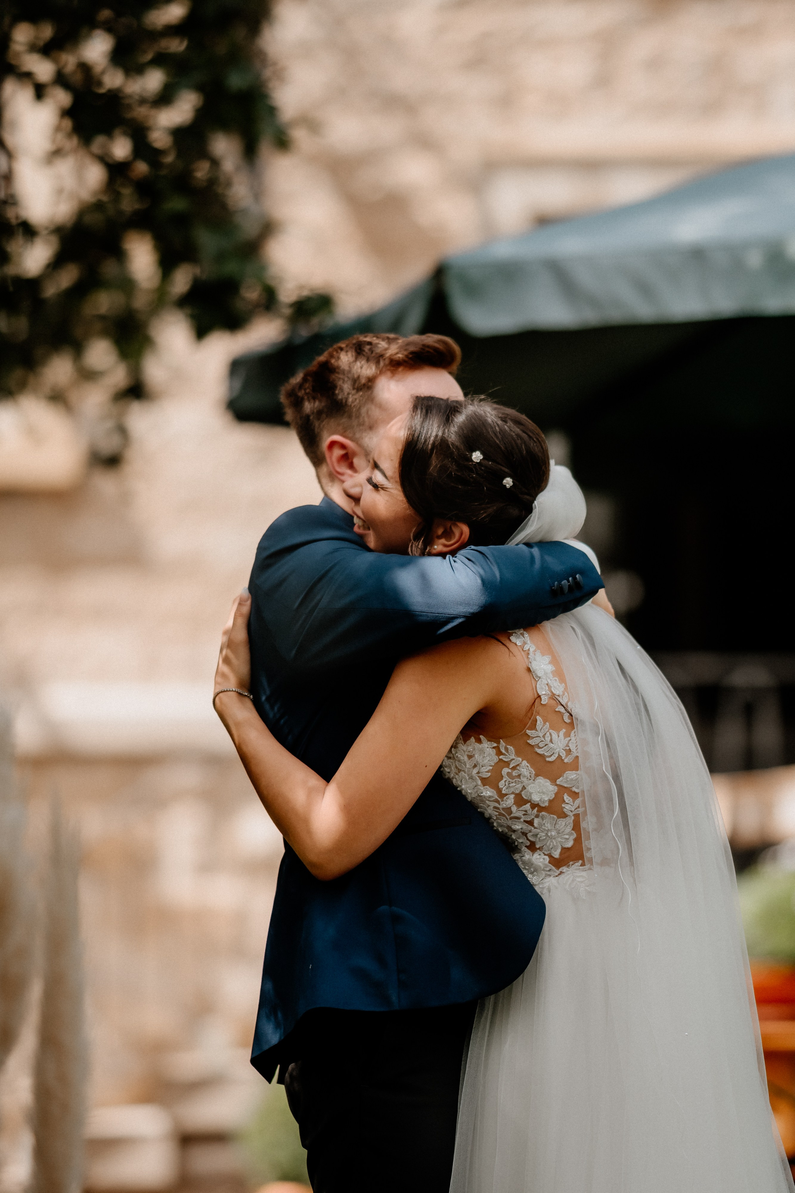 Lächelnder Bräutigam sieht seine Braut zum ersten Mal im Hochzeitskleid